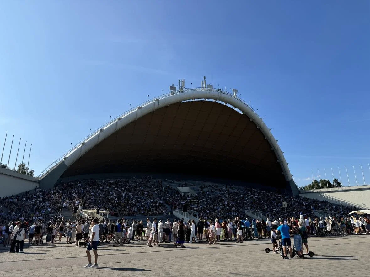 Large outdoor amphitheater with a crowd under a clear blue sky.