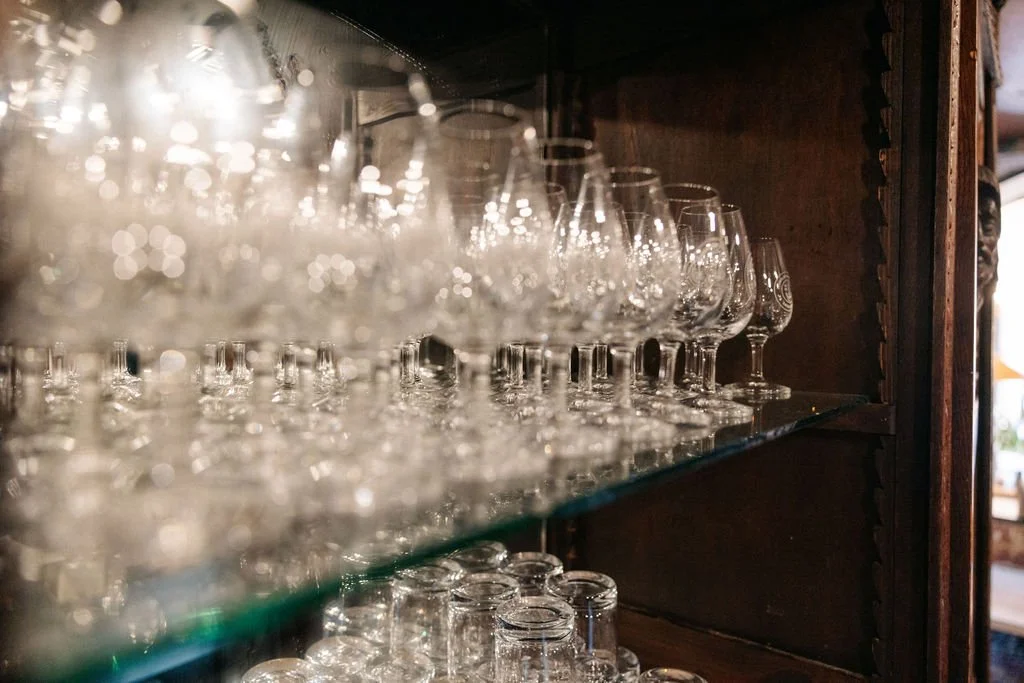 Bourbon glasses on shelving at Ironclad Inn Fredericksburg Virginia whiskey bar