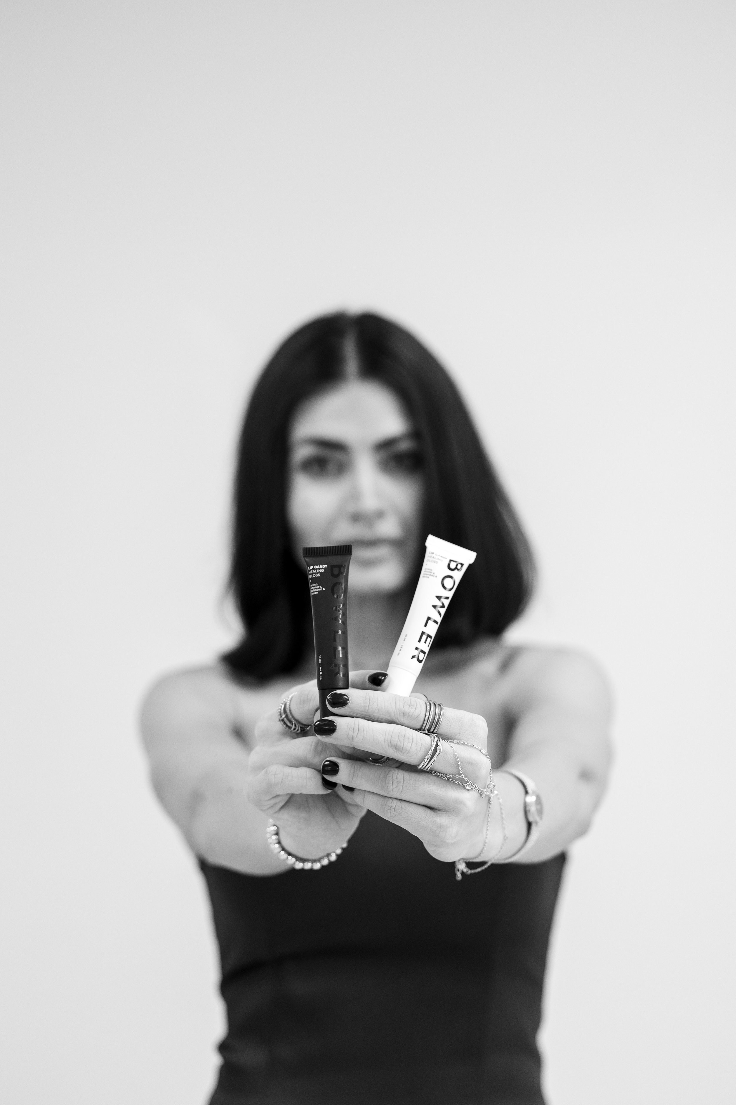 Model holding Bowler Lip Candy products, a hydrating luxury lip treatment designed to nourish, protect, and enhance lips, available at Twin B Beauty Co in Canyon Texas alongside professional skincare and esthetic services.