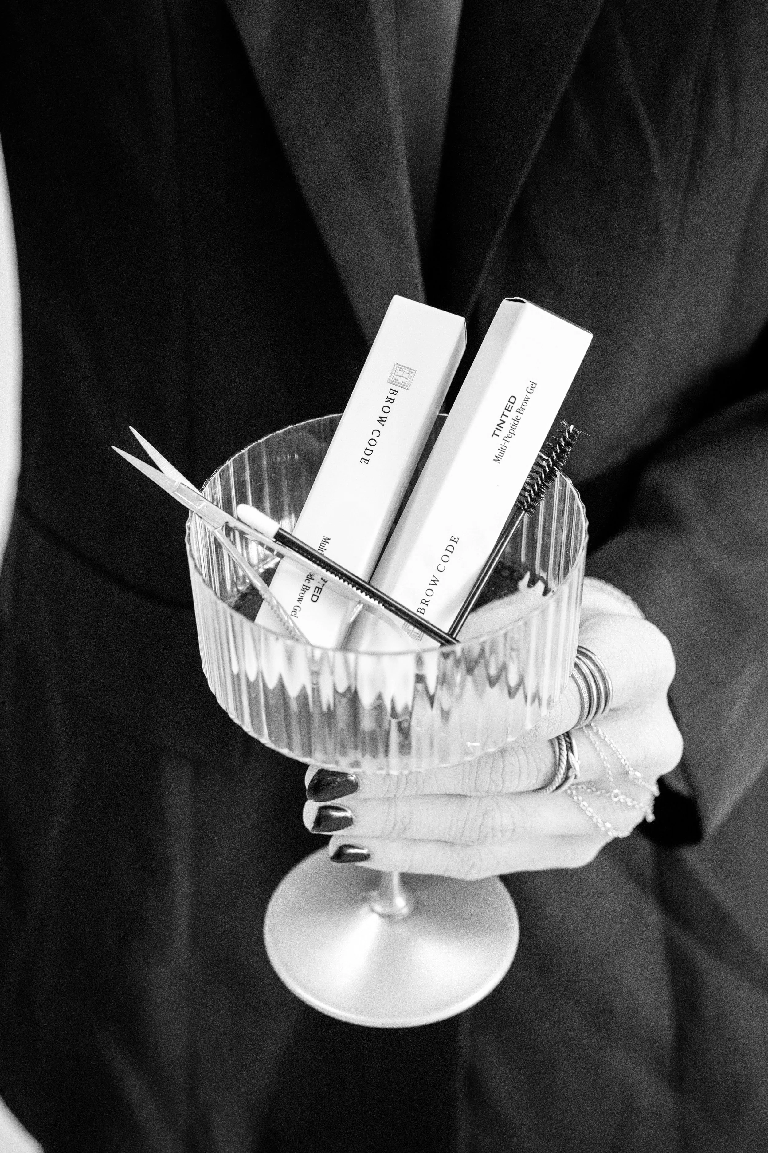 Brow Code professional eyebrow products displayed in a glass bowl, used for brow shaping, tinting, and lamination services at Twin B Beauty Co in Canyon TX, specializing in precision brow artistry and long-lasting, natural-looking results.