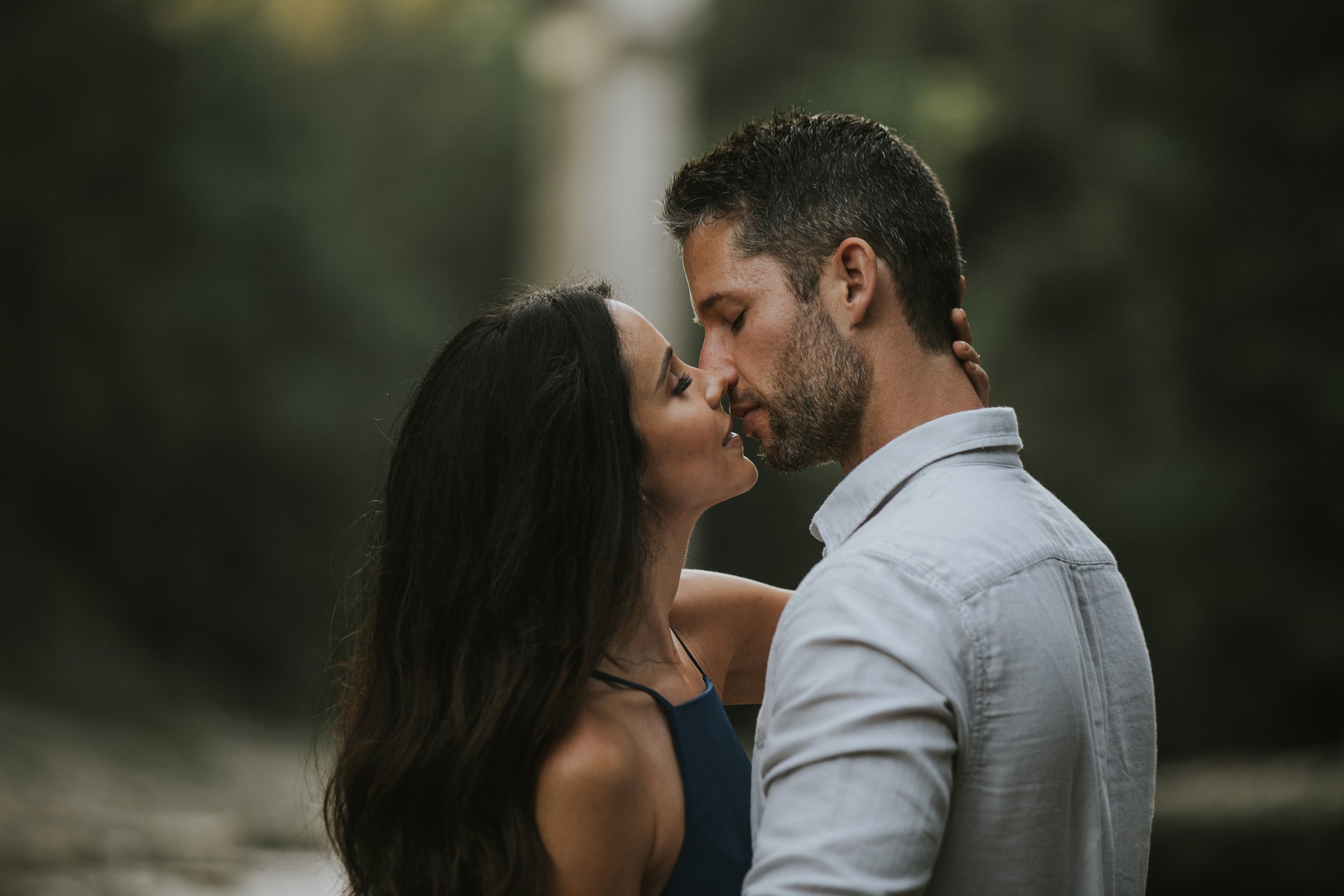 Couple sharing a romantic kiss while standing close together at Elora Gorge, captured during their engagement session.