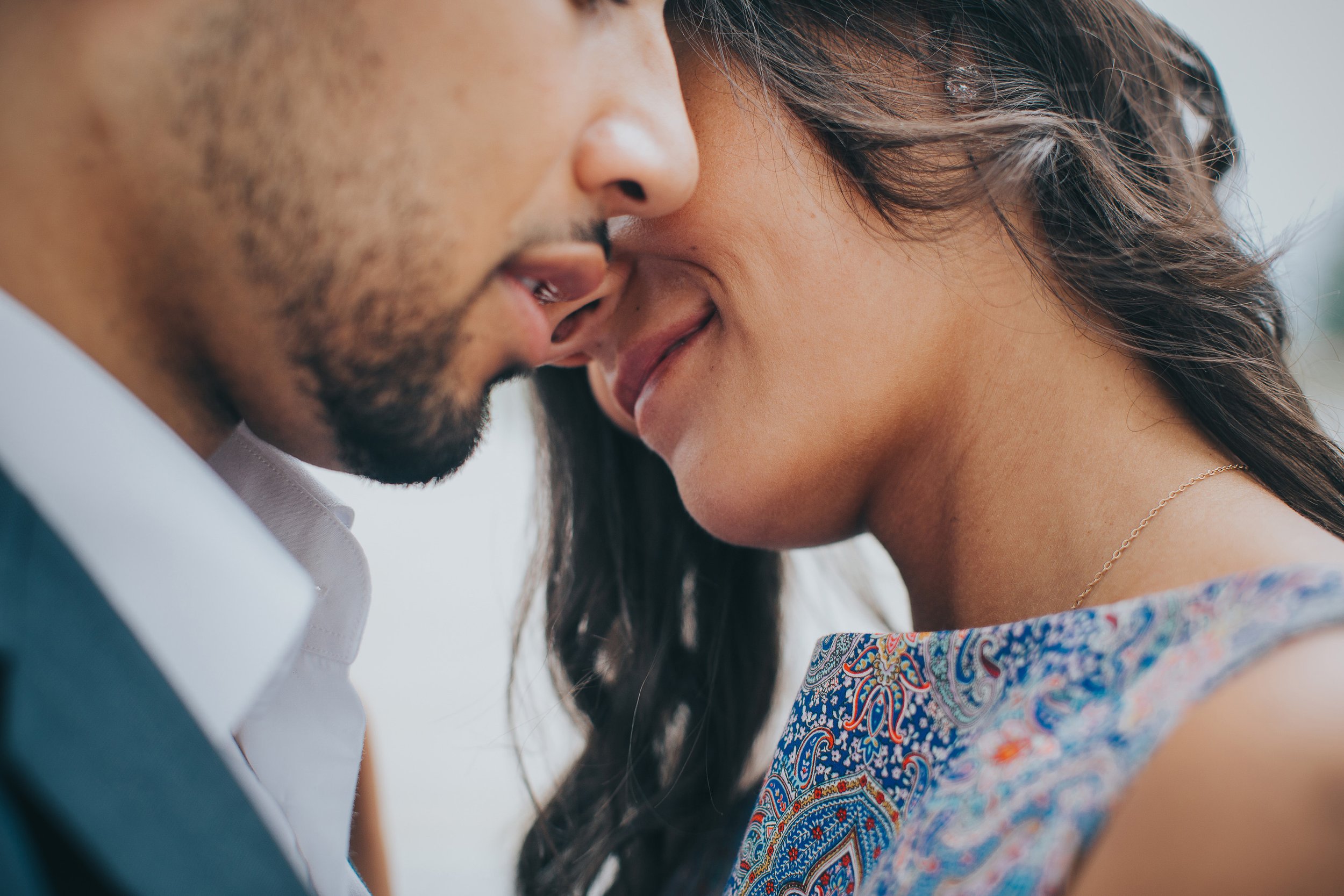 A close-up of an intimate moment between a couple, highlighting their smiles during an engagement session.