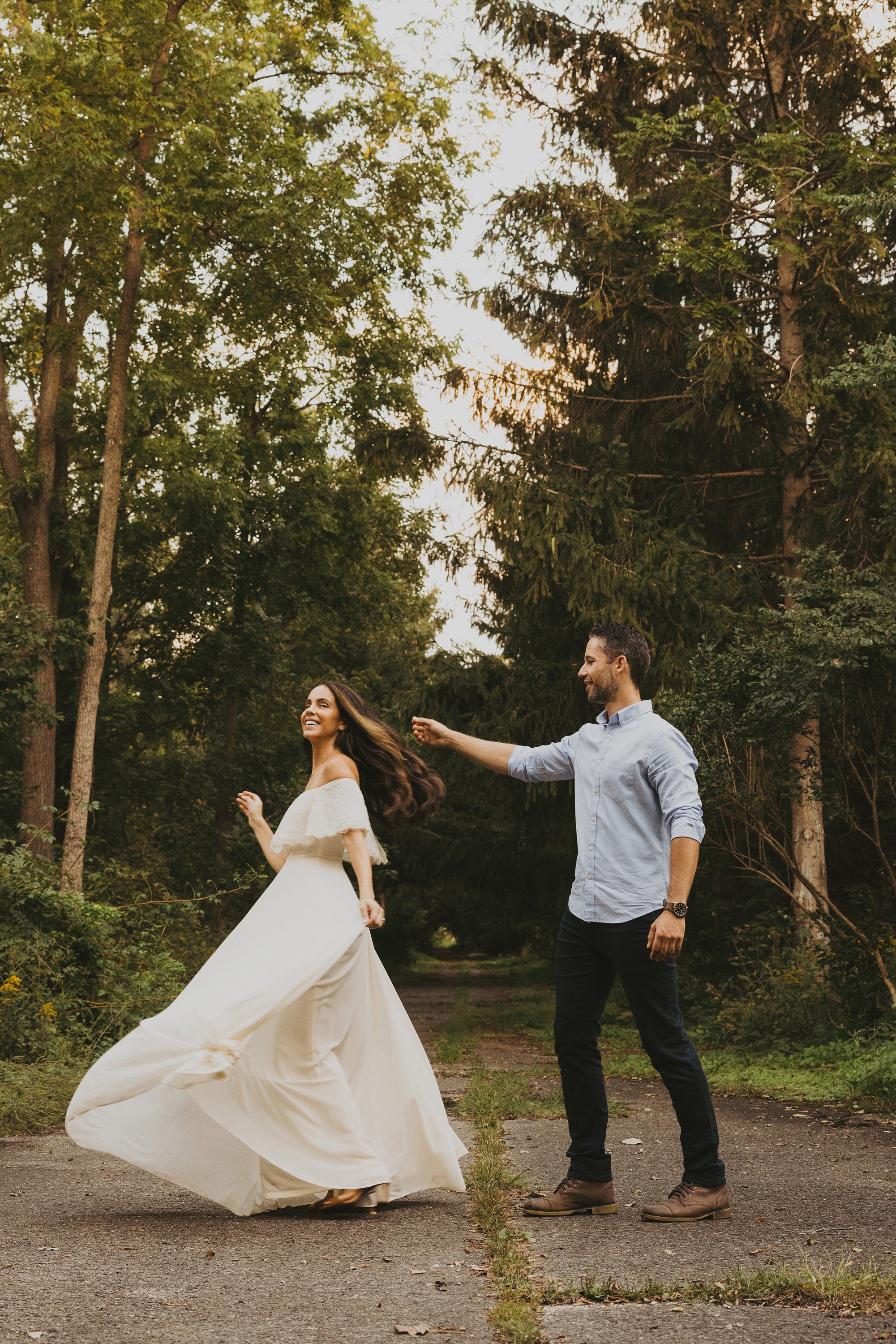 A couple twirls and dances in a forest, capturing a moment of love and connection.