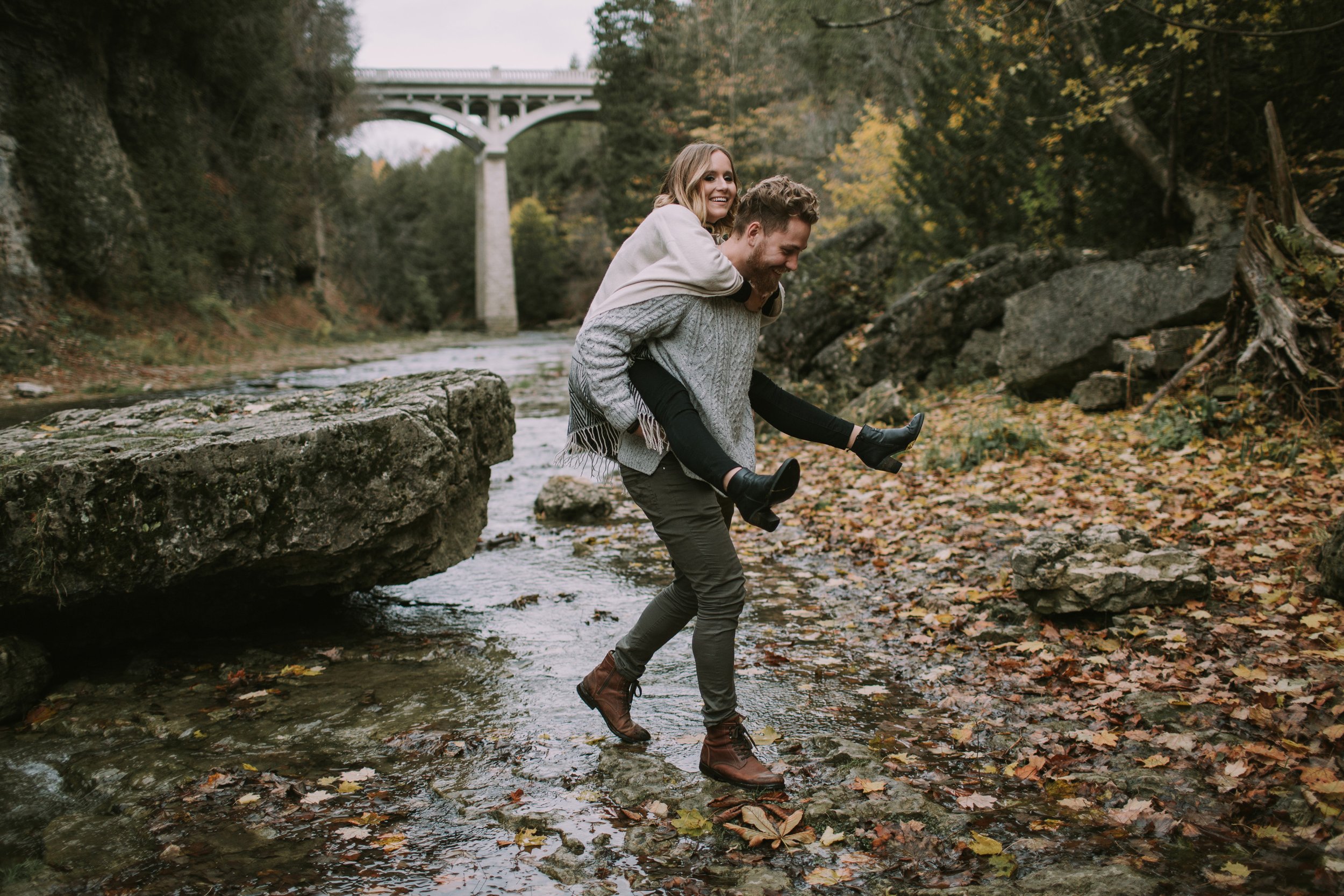 A dramatic photo of a couple embracing in a moody forest setting, filled with emotion and connection.