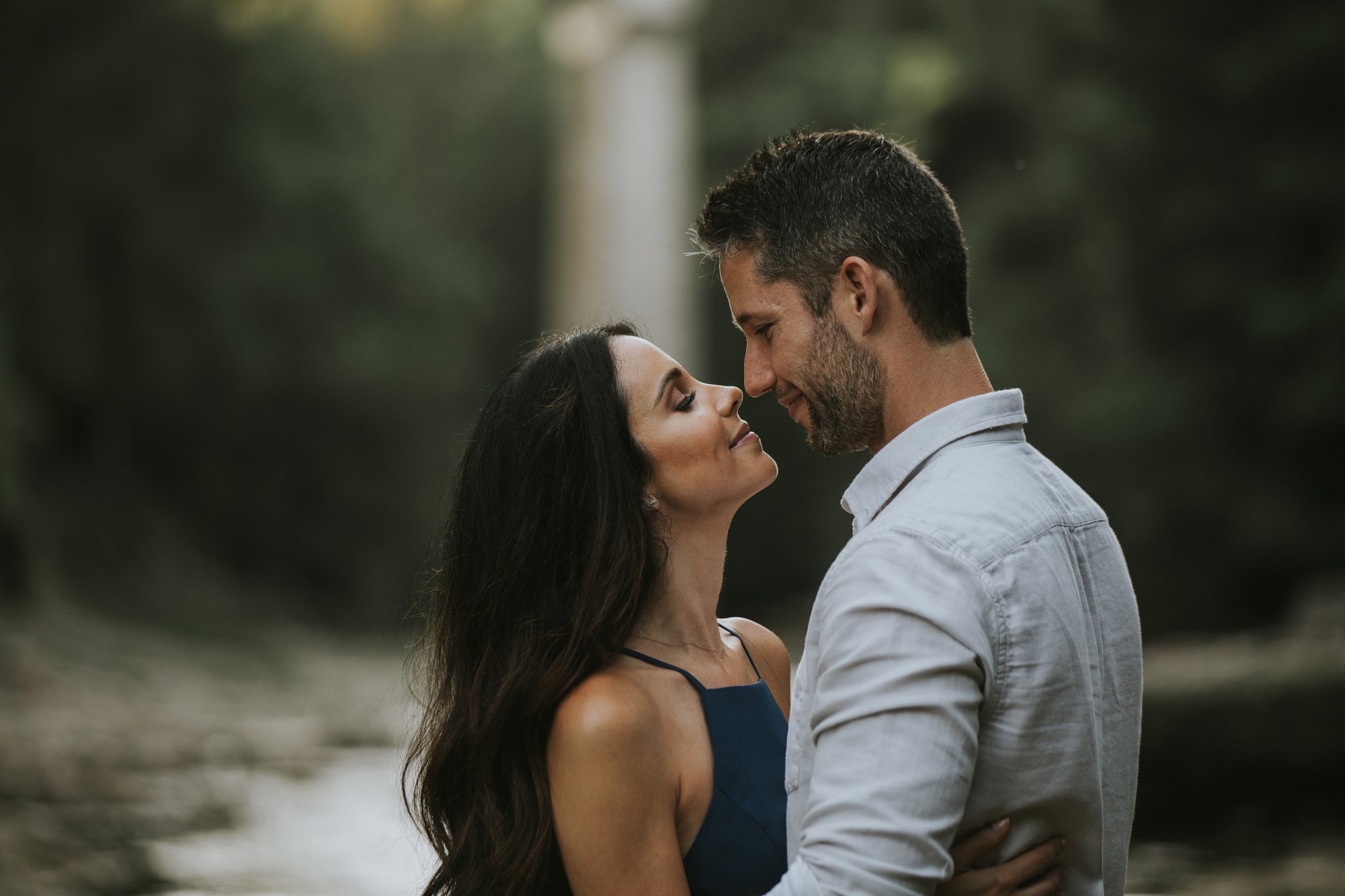 A close-up of a couple gently touching noses while sharing a tender moment in the Elora Gorge.
