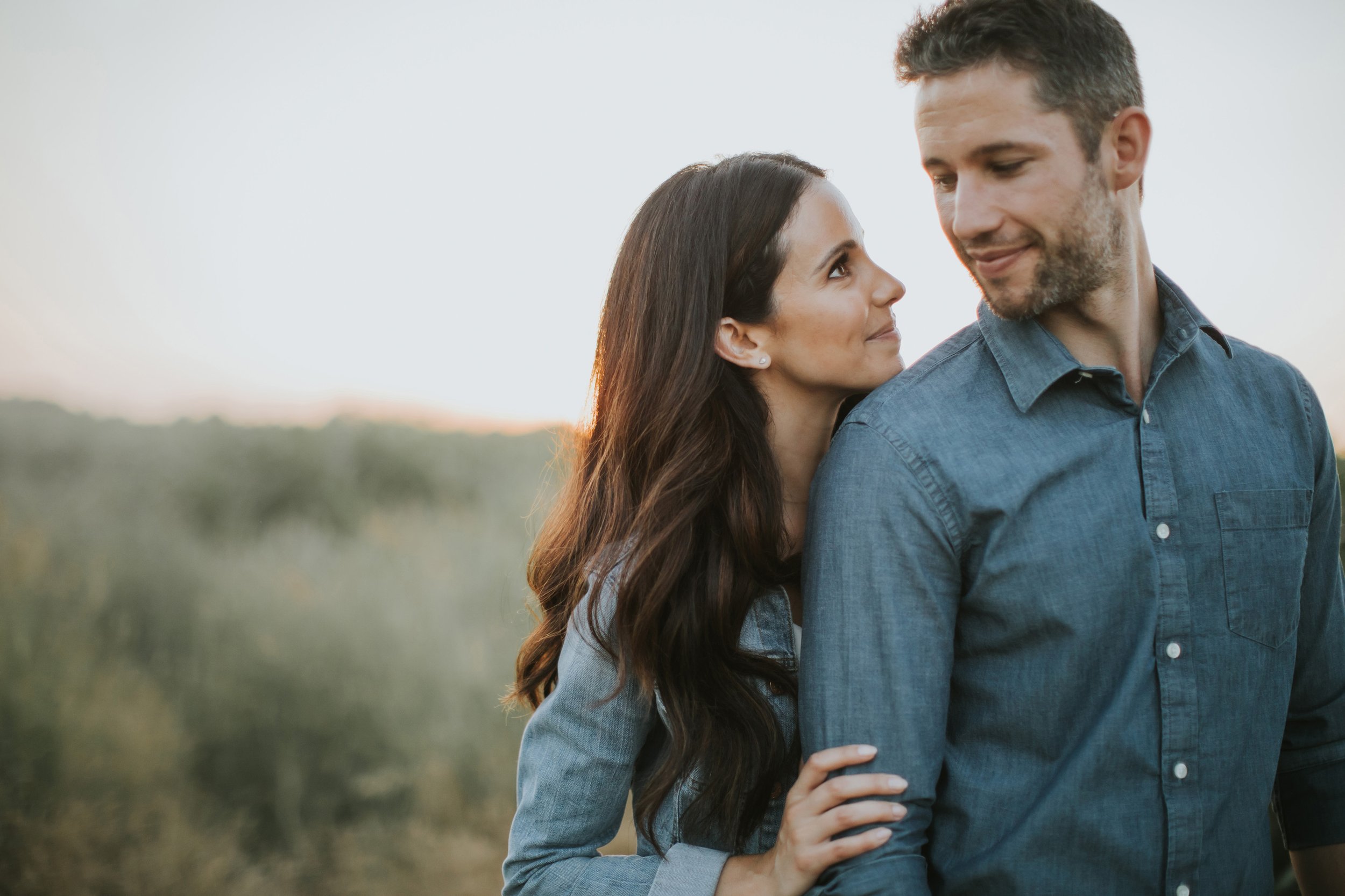 A couple gazes at each other lovingly during sunset in Elora, Ontario, capturing a tender engagement moment.