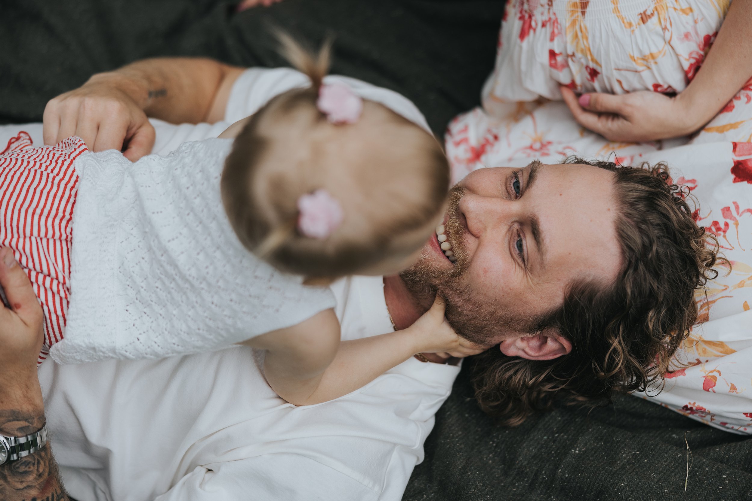 A playful and candid close-up of a father and daughter sharing a joyful moment together.