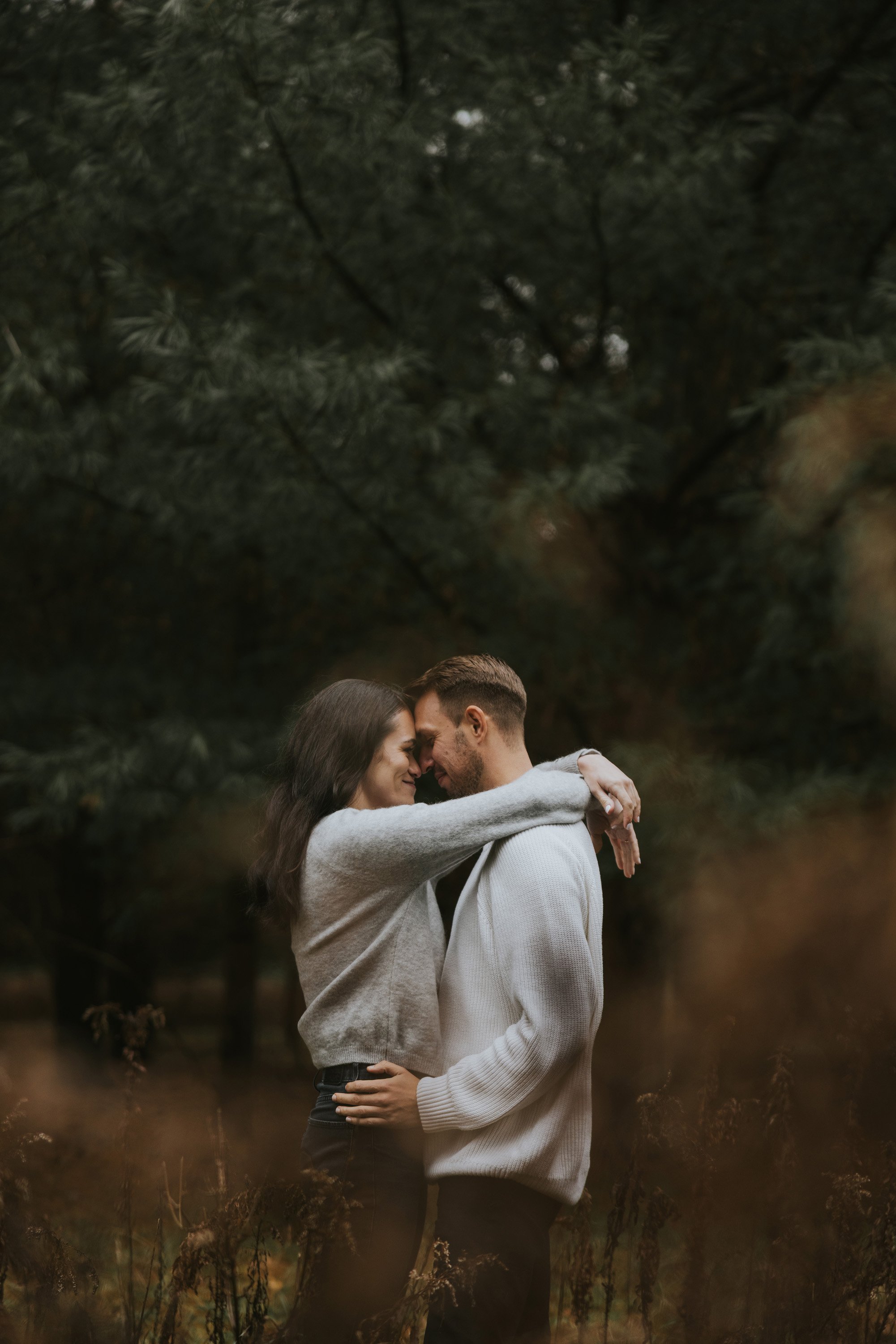 A couple shares an intimate moment, embracing each other in the wilderness, surrounded by the beauty of nature.