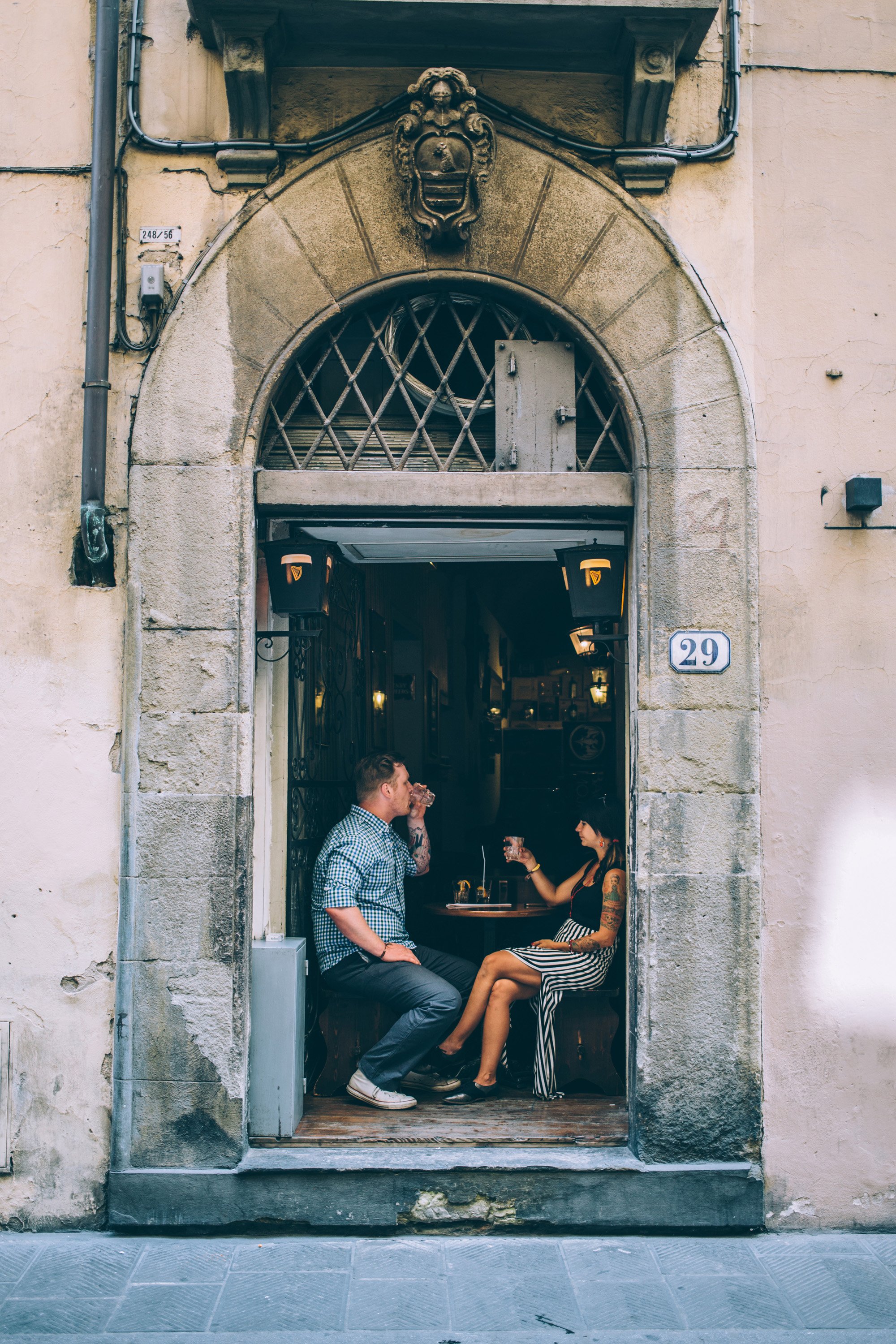 A couple enjoys a romantic moment inside a historic cafe, sitting across from each other in a cozy and intimate setting.