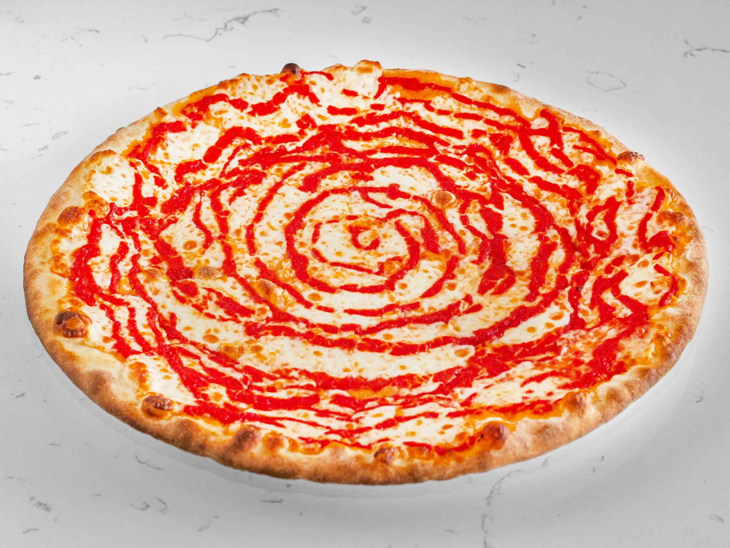 Cheese pizza with ketchup drizzle on a white surface.