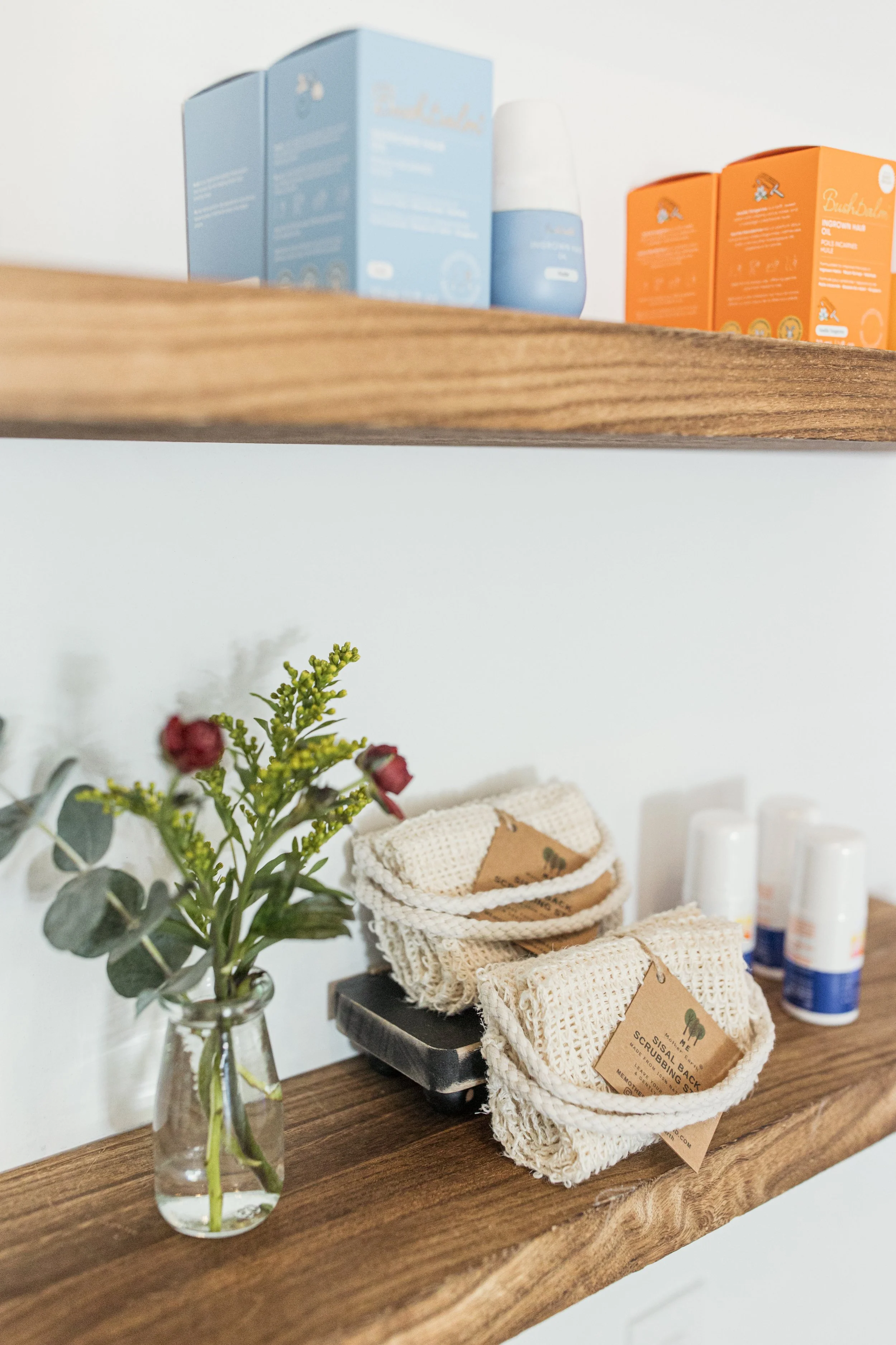 Post-wax skincare products, exfoliating gloves and body care essentials displayed at Neighborhood Wax in Denver.