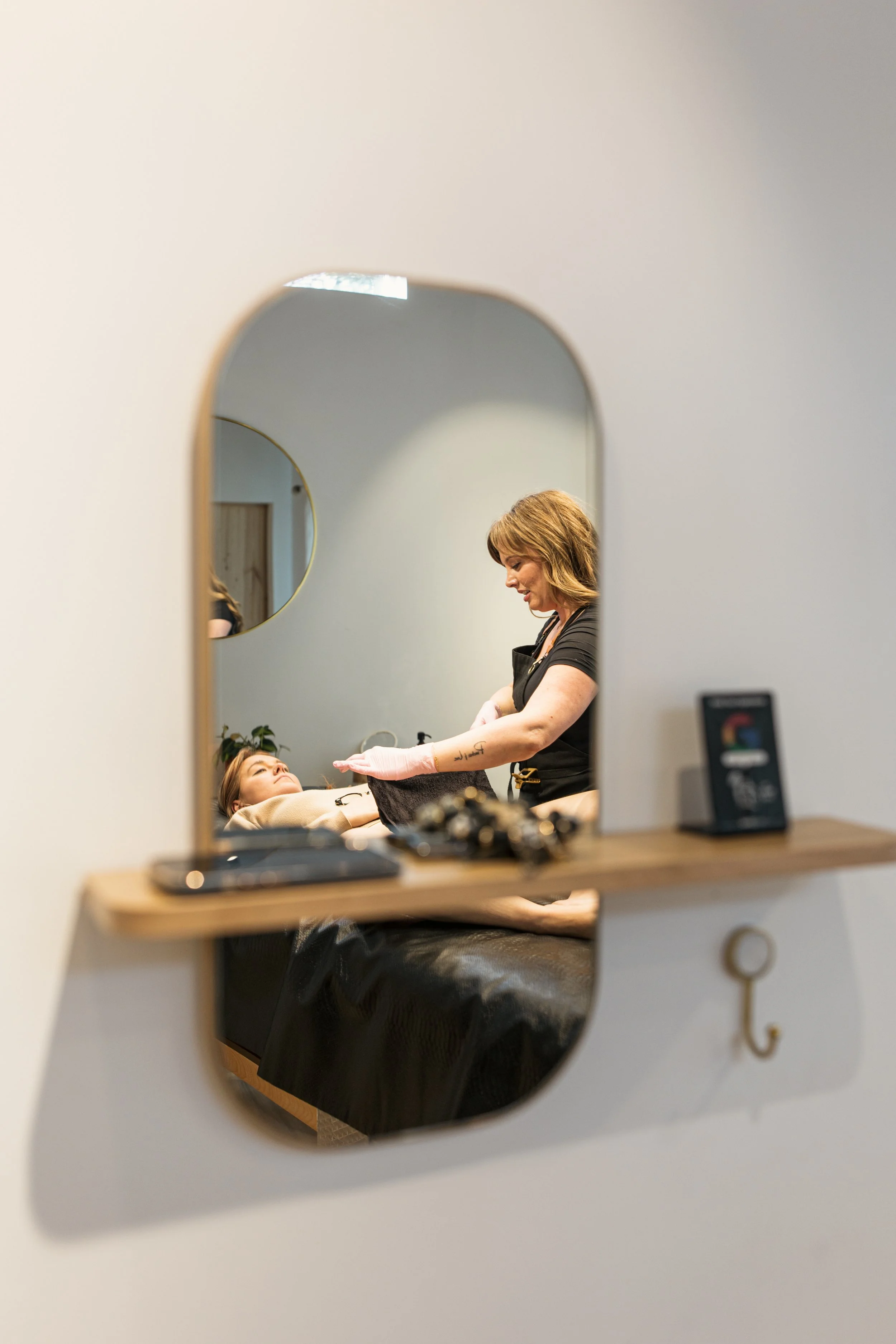 Esthetician caring for a client during a Brazilian waxing appointment at Neighborhood Wax in Denver.