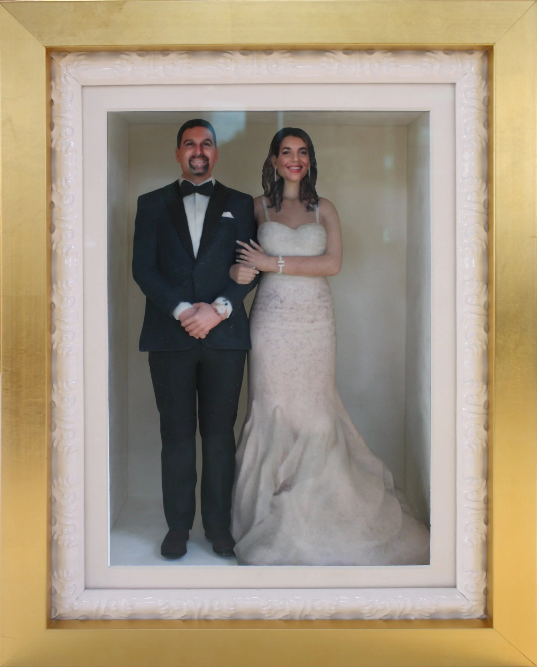 Framed portrait of a smiling man and woman in wedding attire, standing side by side. Custom Framed Wedding topper in a shadowbox.