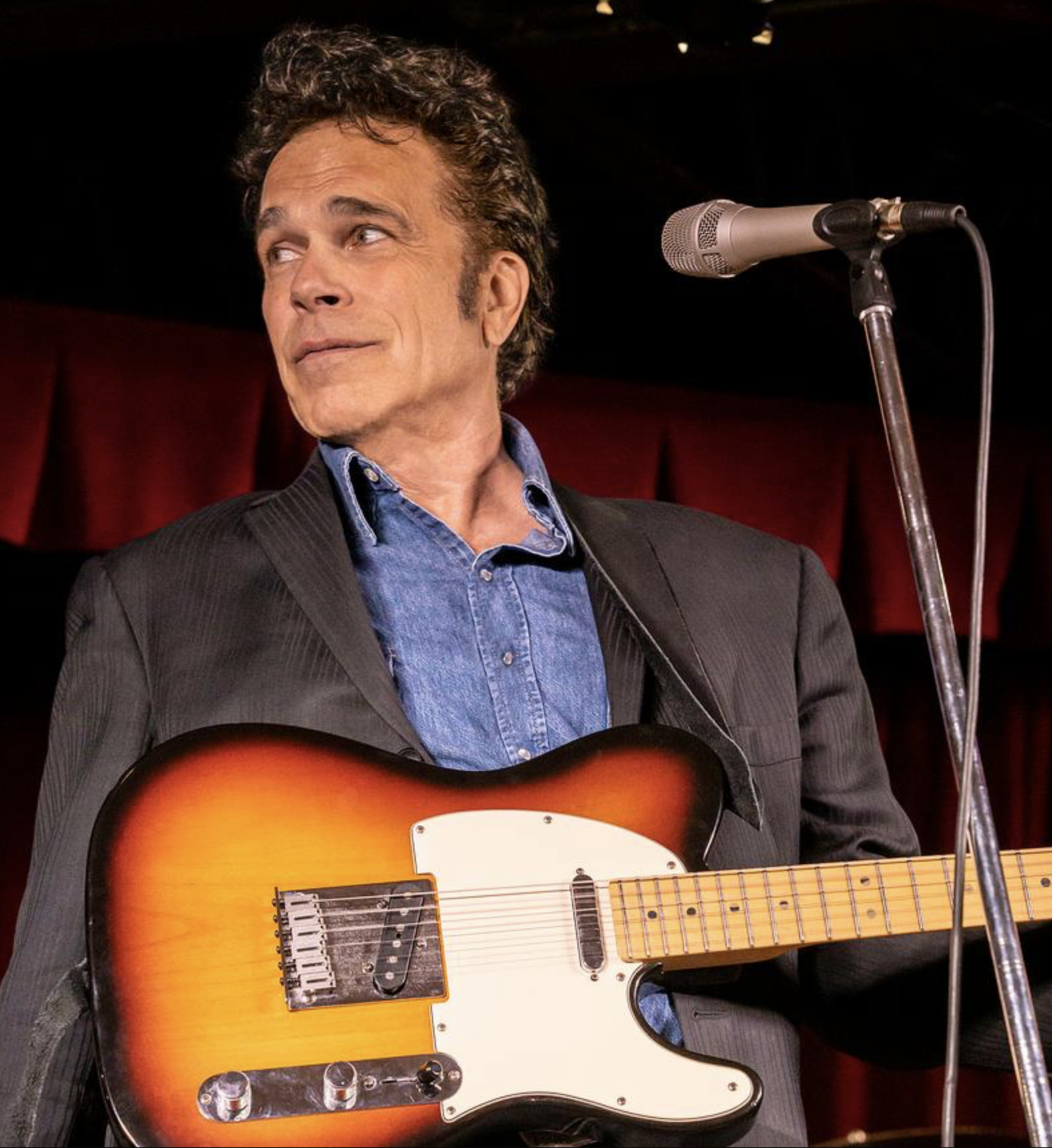 Bobby Vandell on stage with a guitar