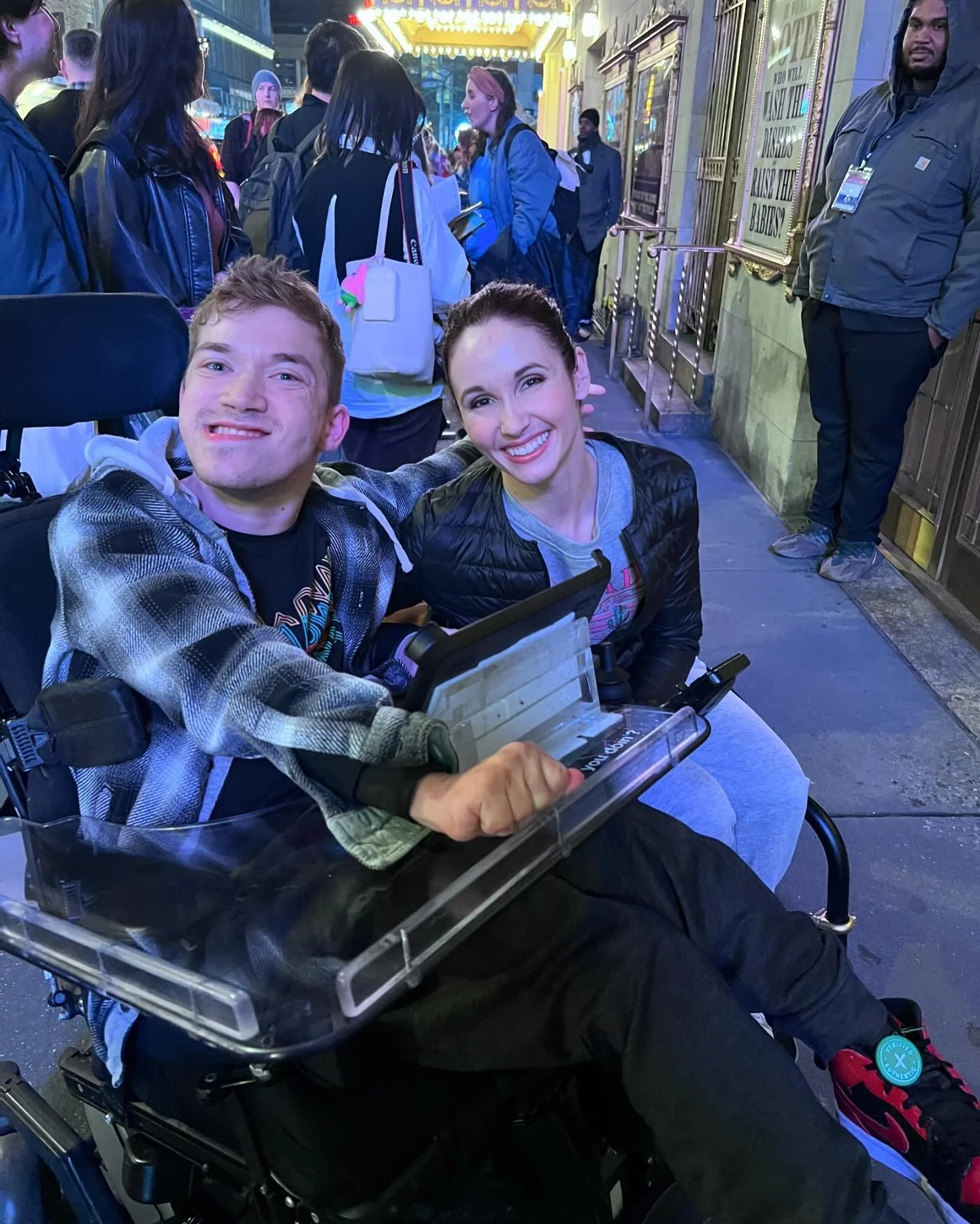 Thomas smiles with Jenna Bainbridge, a disabled actor, outside of a Broadway theatre.