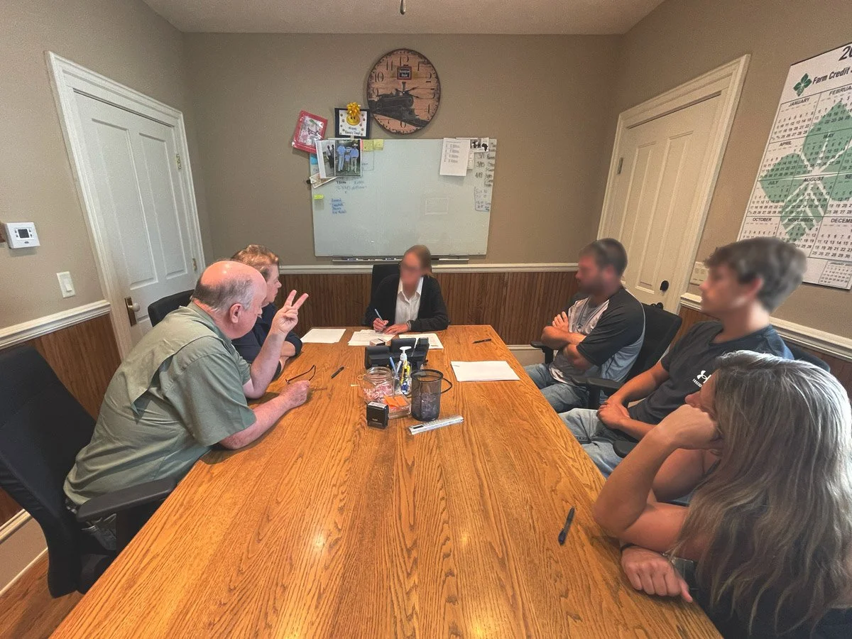 Buyers and sellers meet at a real estate closing for a land sale in Iowa.