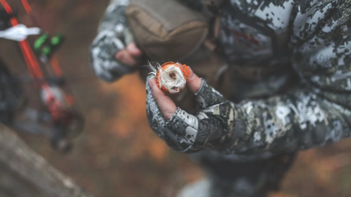 An image of milkweed being used to watch wind currents for bowhunting.