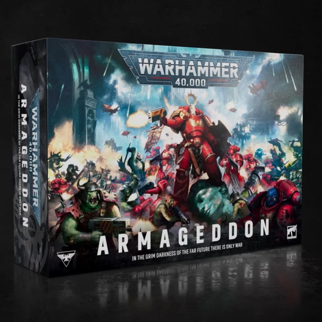 A box for the tabletop game Warhammer 40,000 Armageddon, depicting a battle scene with armored soldiers, alien creatures, and explosions in a sci-fi setting.