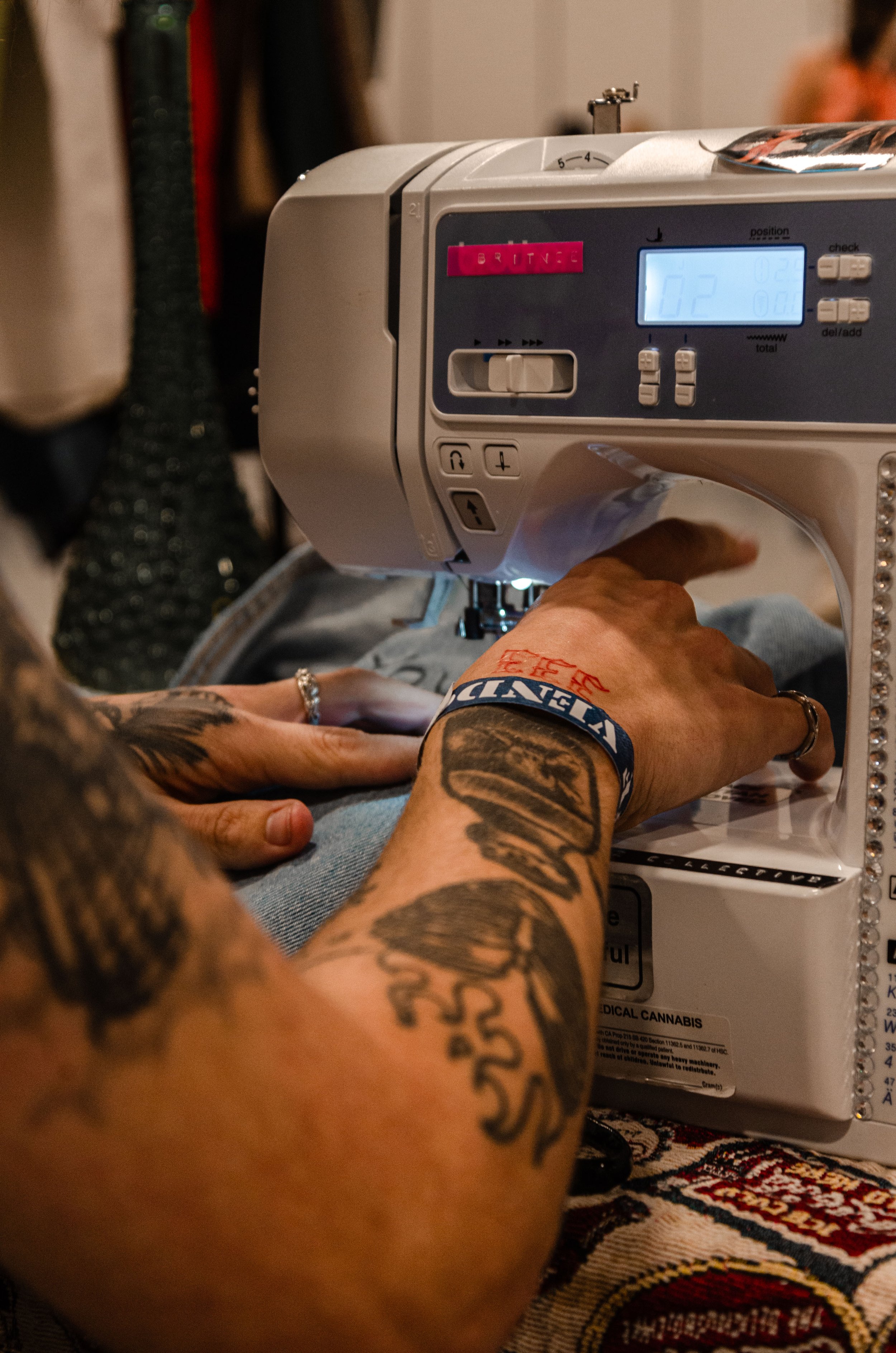 Person sewing fabric with a sewing machine.