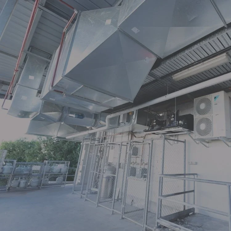Industrial air conditioning or ventilation system with ductwork and cooling units mounted on a building exterior