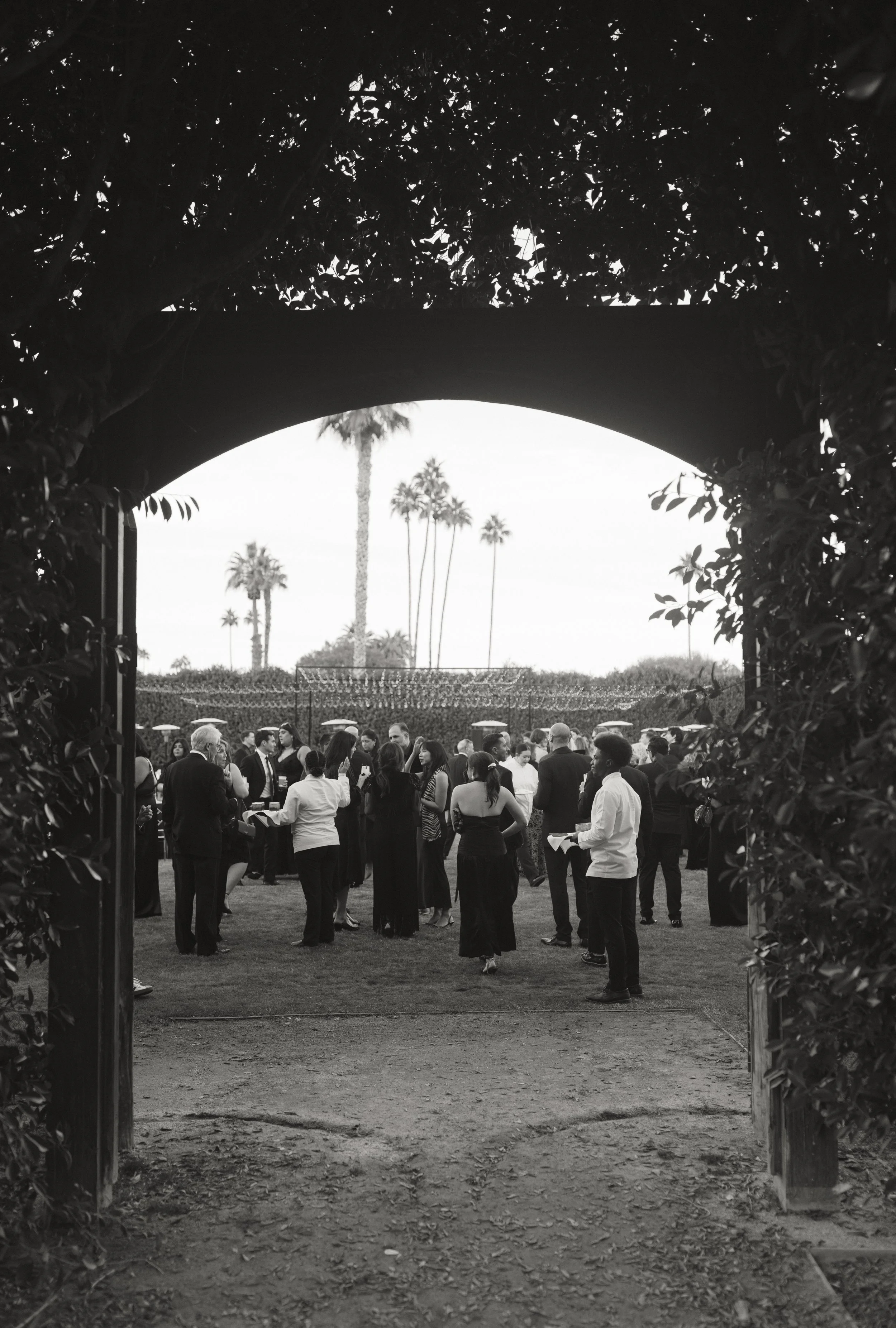 Guests gathered under an archway at an event produced by Charmstrongs
