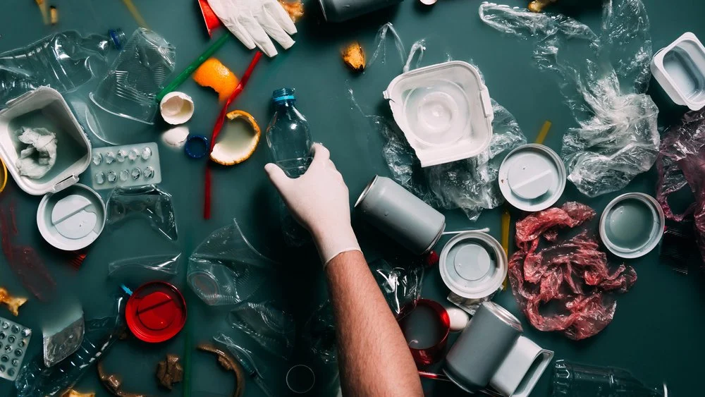 a hand sorting plastics and rubbish