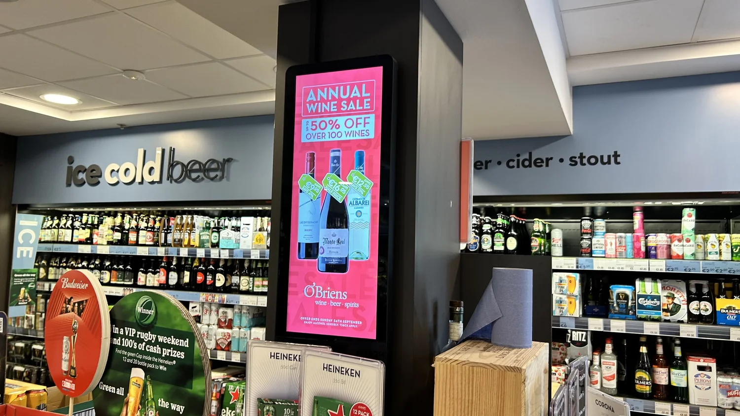 An O'Briens own-brand wine promotion running on an in-store screen.