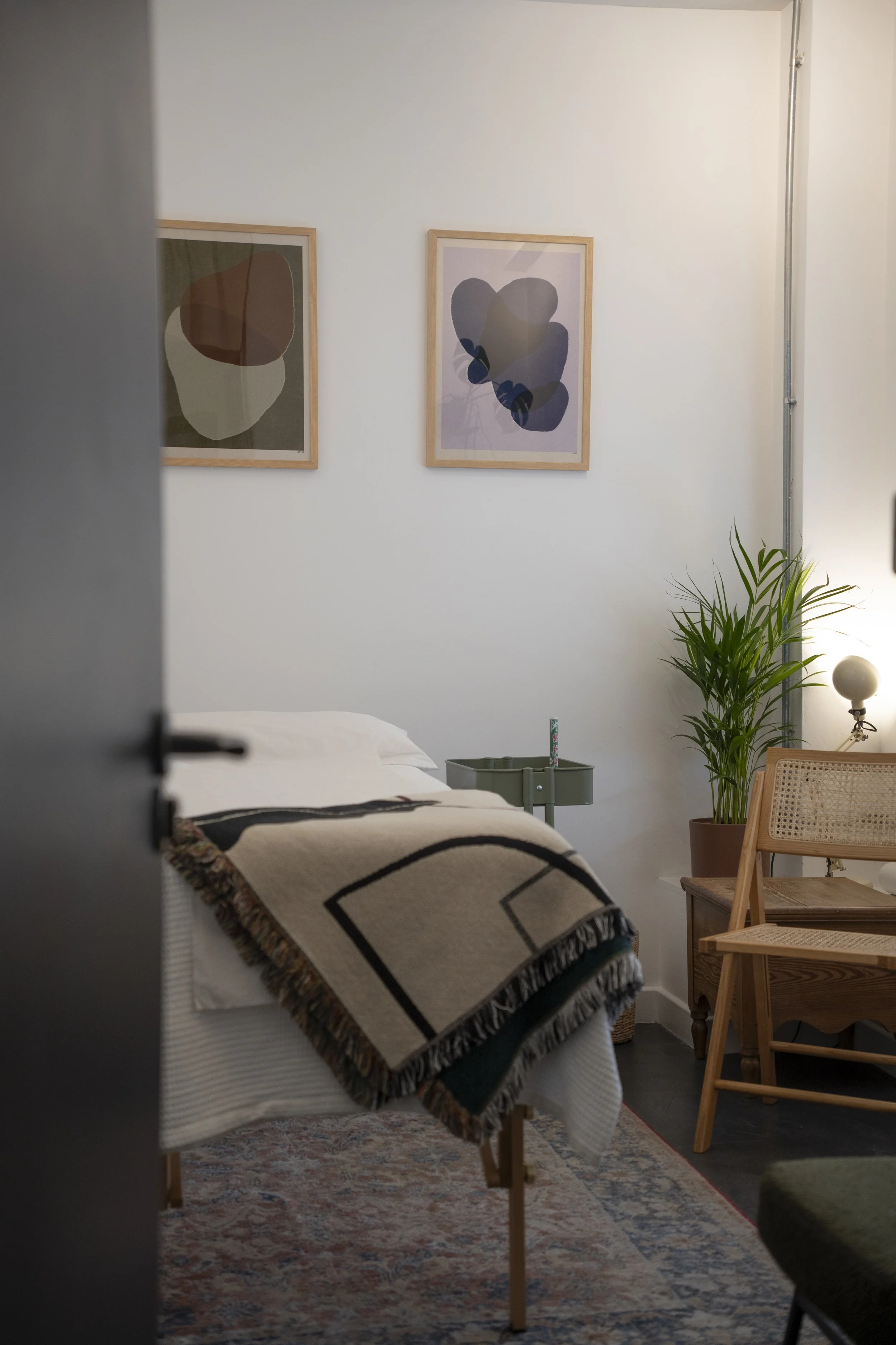 A calm and light-filled acupuncture treatment room at Netil House, London Fields, featuring a comfortable treatment couch and minimalist decor.