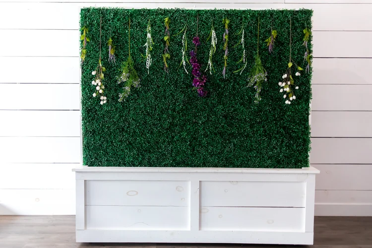 The Living Room furnished with seating, a plant wall and warm lighting