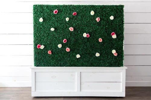 Roses arranged across the greenery wall