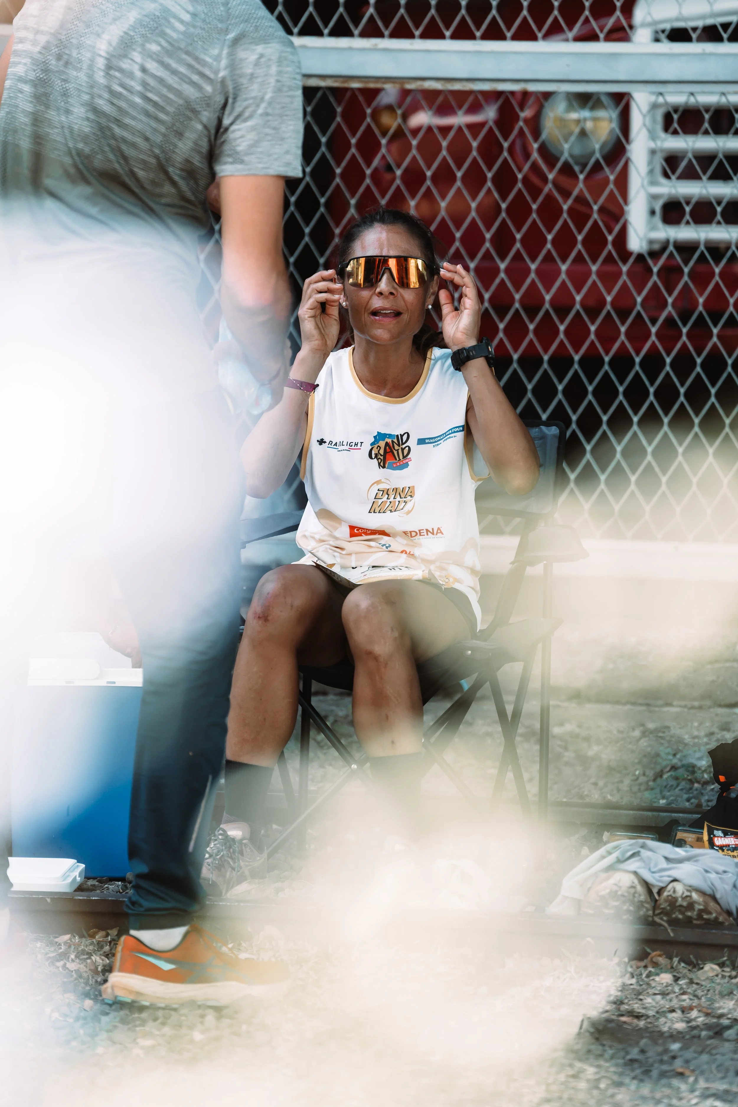 Sylvaine Cussot wearing a Grand Raid t-shirt and sunglasses looking surprised ad the camere