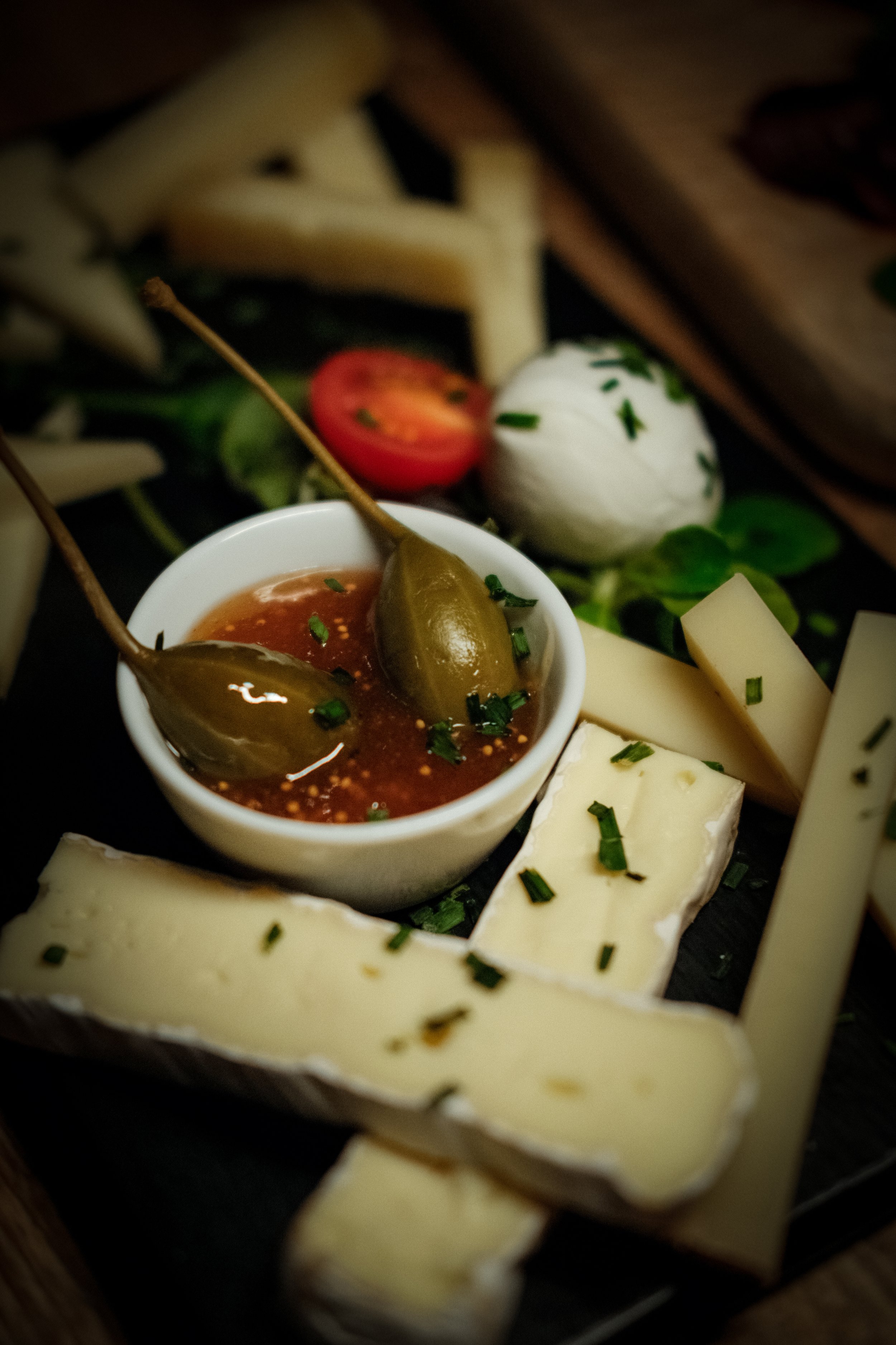 A cheese platter paired with red wine, showcasing gourmet food photography at the bar.