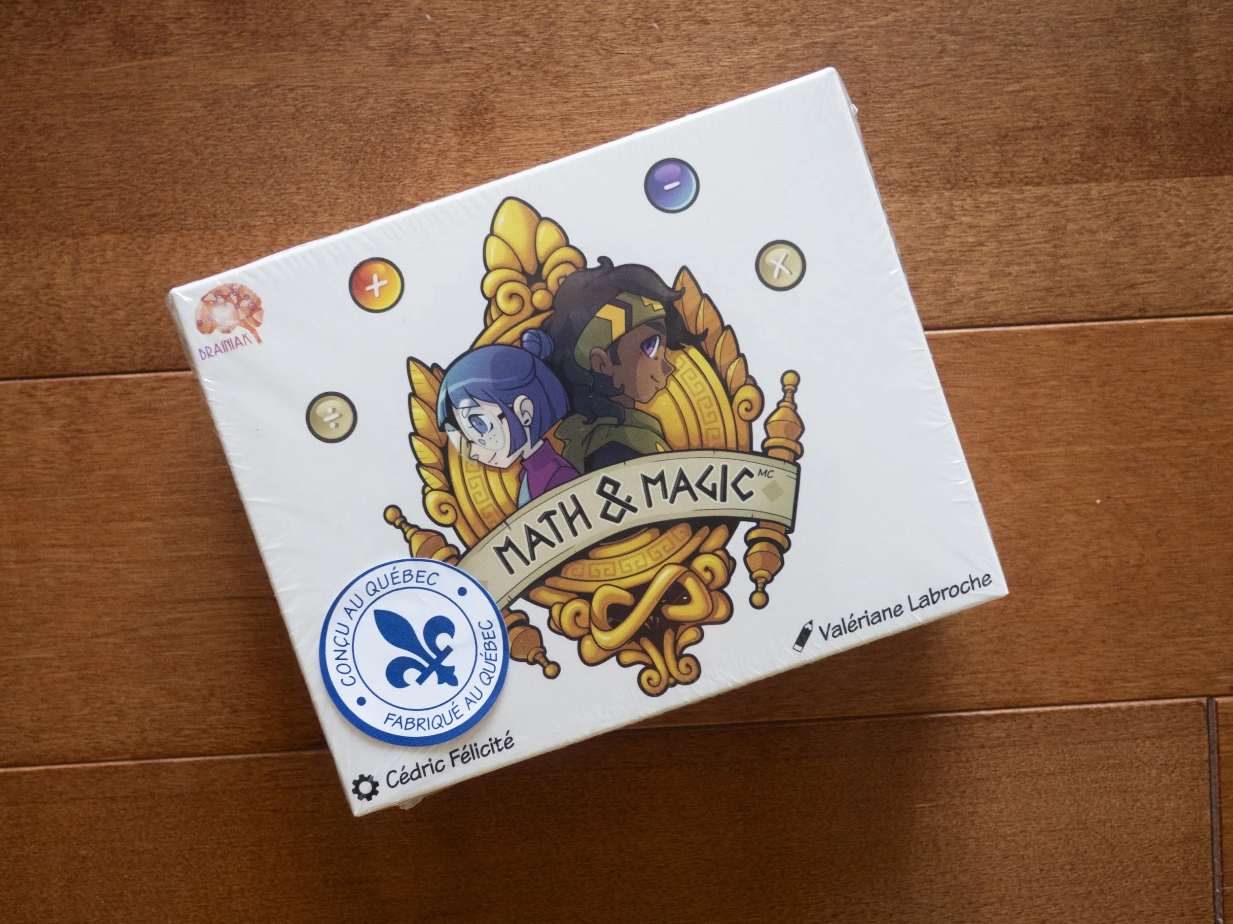 La boîte du jeu Math & Magic, avec Math et Maggie sur le couvercle et le sceau « Conçu au Québec, fabriqué au Québec »