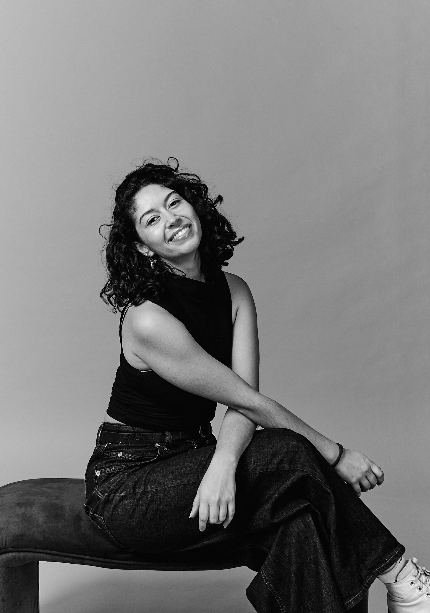 Black and white photo of a person dancing, wearing a patterned shirt, black top, and light-colored pants.