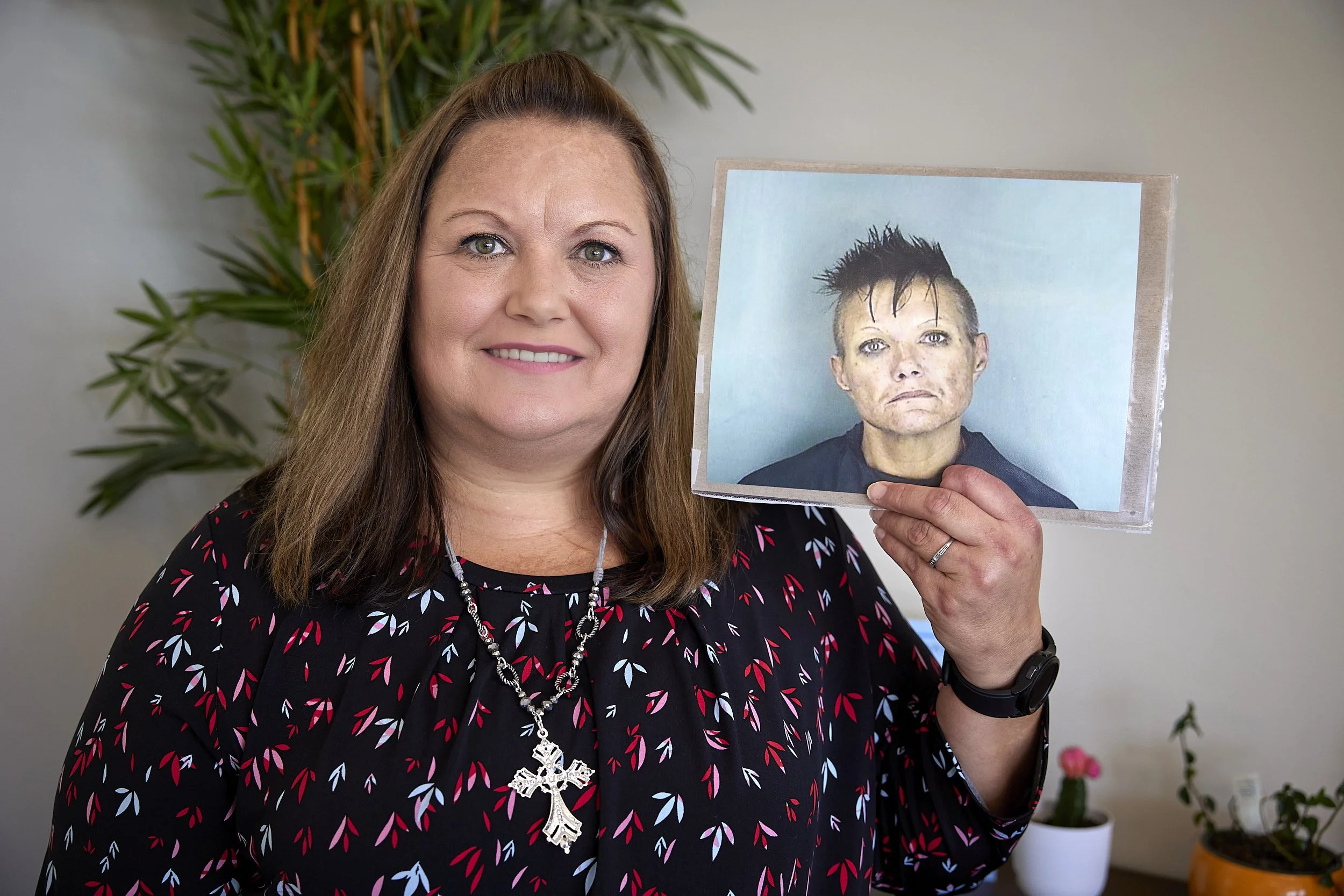 Woman holds up a photo of her former self before having her life transformed.