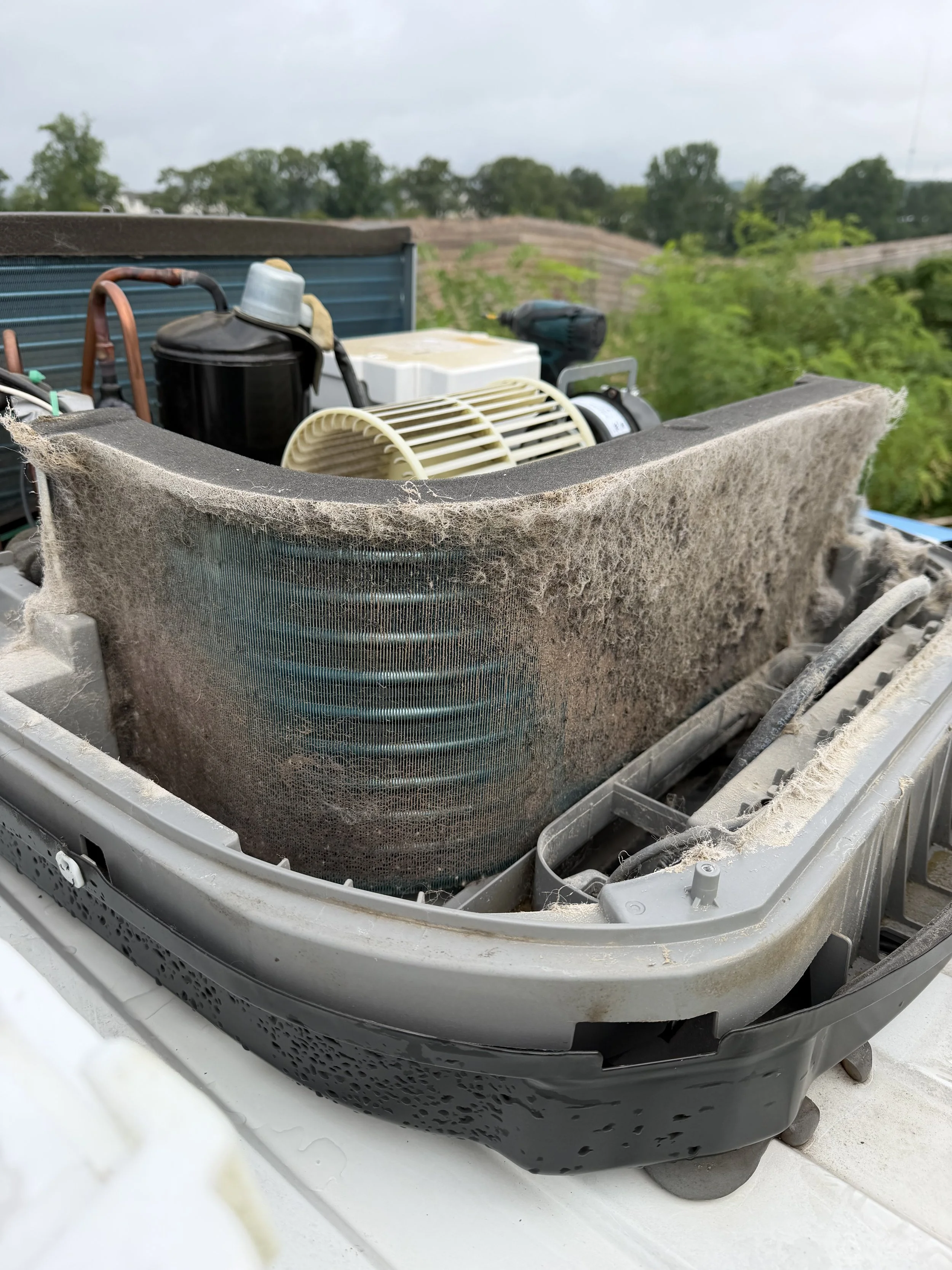 Debris being removed from an RV rooftop air conditioner