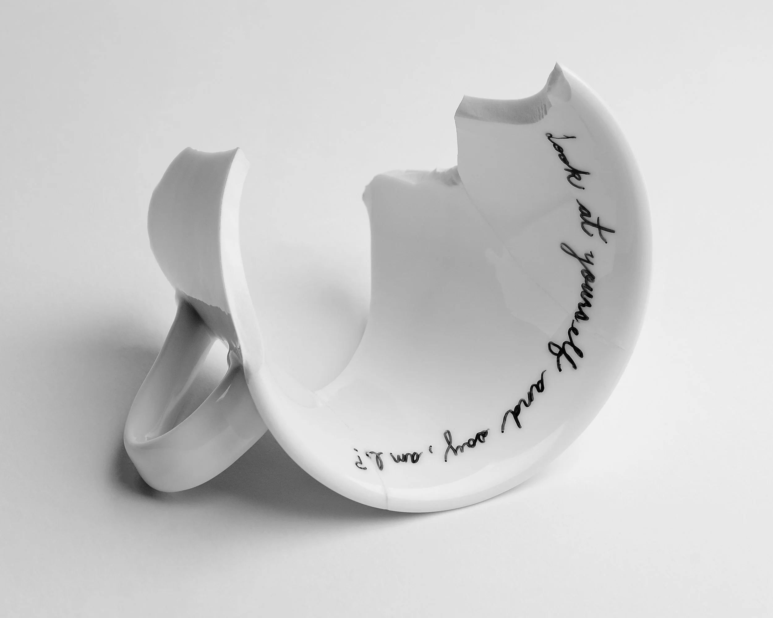 broken cup with cursive text written around the inner rim