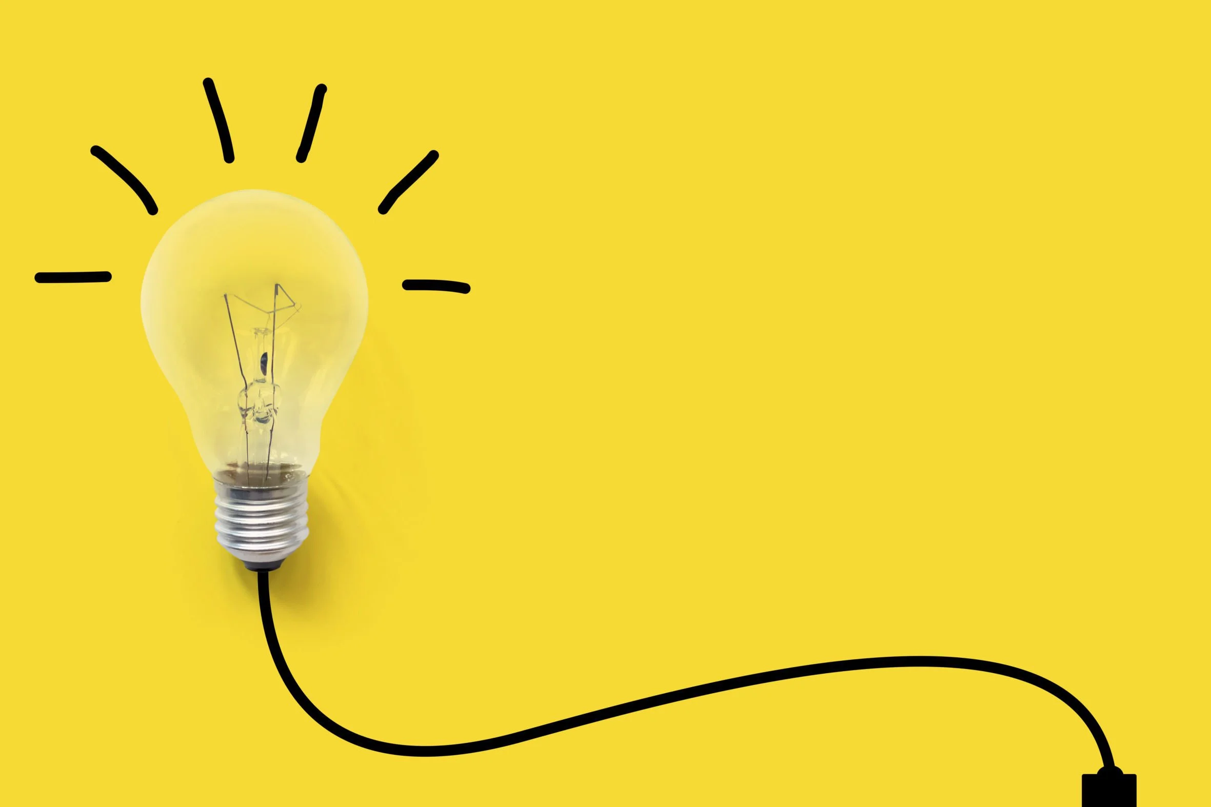 A lightbulb with a yellow background and black line drawing accents around the bulb, connected to a black wire.
