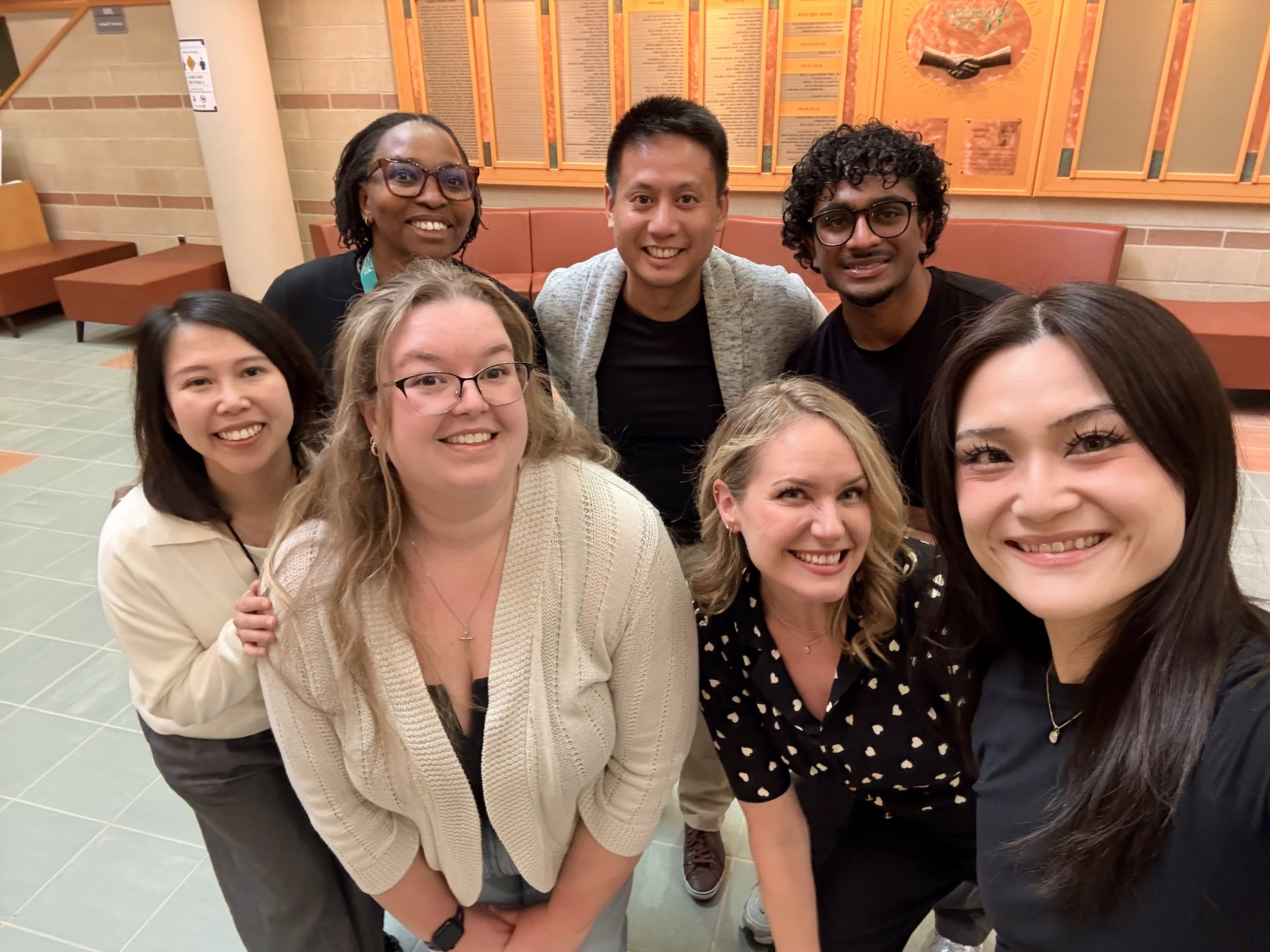 Group photo in the Helen Glass Atrium (April 2026) — Left to right: Clara Tam, Dr. Kina Kombo, Michaela Bourque, Raymond Chhun, Dr. Mandy Archibald, Tyler Fernando, and Amy Abegglen