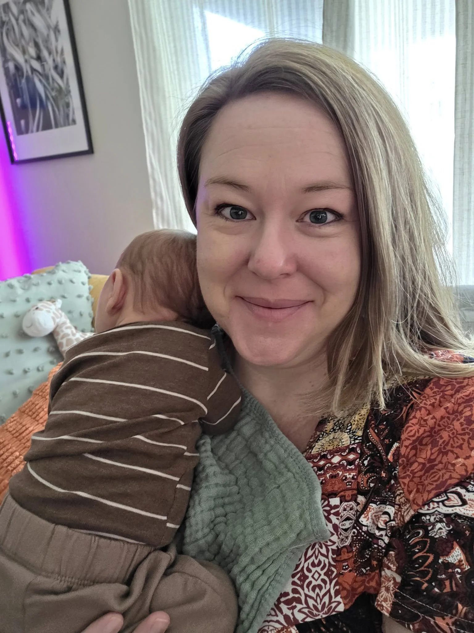 blonde woman holding a newborn baby