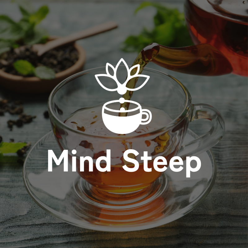 A glass teacup with hot tea on a wooden table, with a teapot pouring tea into it and some fresh mint and loose tea leaves in the background. Overlay with a logo and the text 'Mind Steep'.
