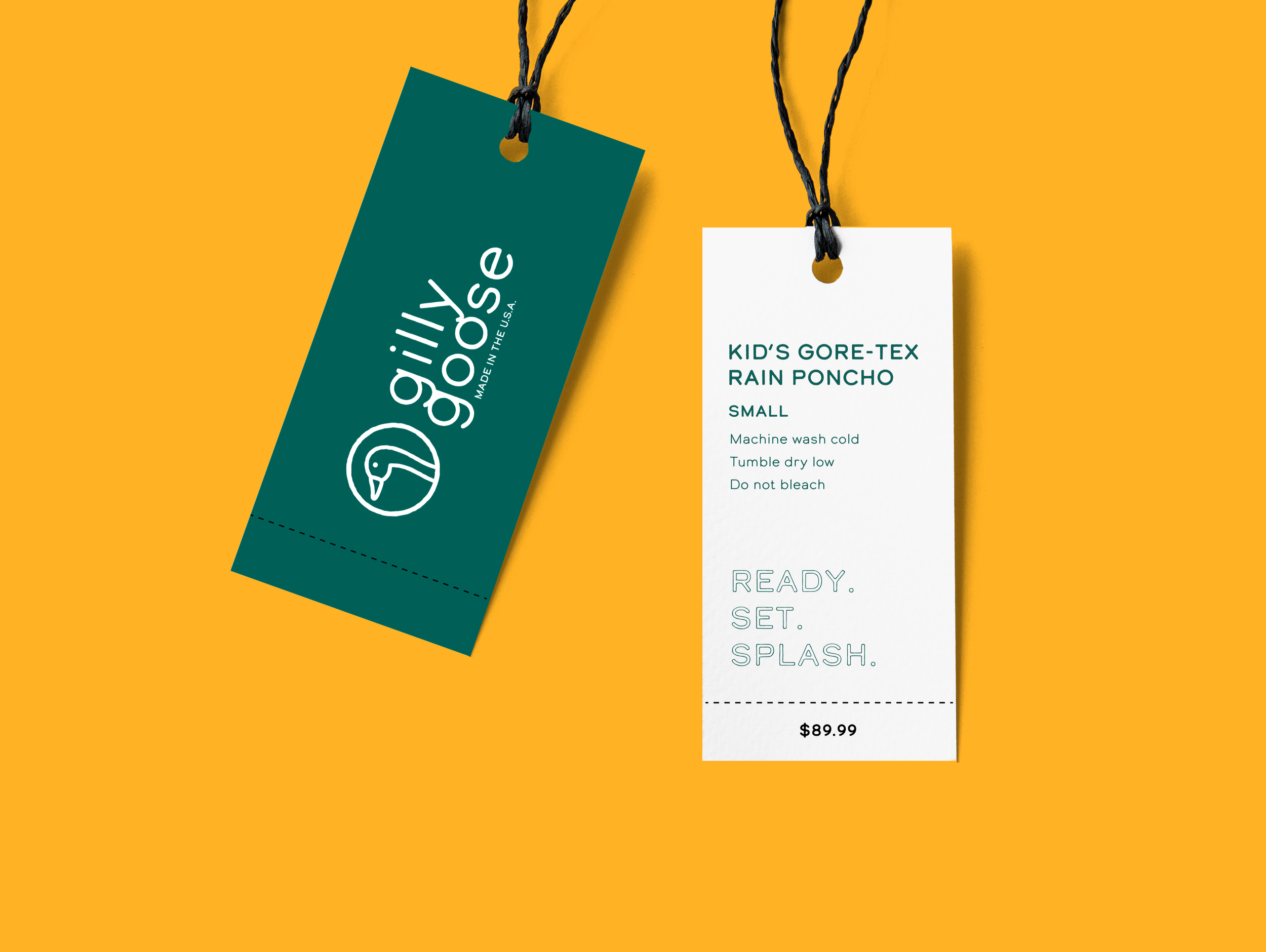 Tags for children's rain poncho with brand logo on dark green tag and product details on white tag against orange background.