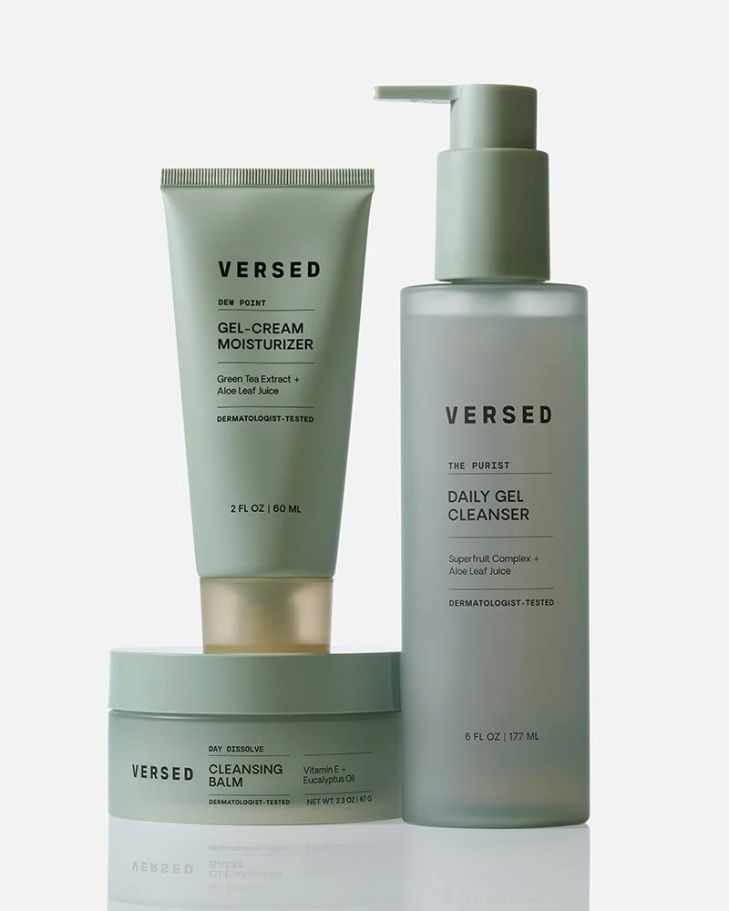 Three skincare products from the brand Versed, including a gel-cream moisturizer, a daily gel cleanser, and a cleansing balm, arranged on a white surface against a light background.
