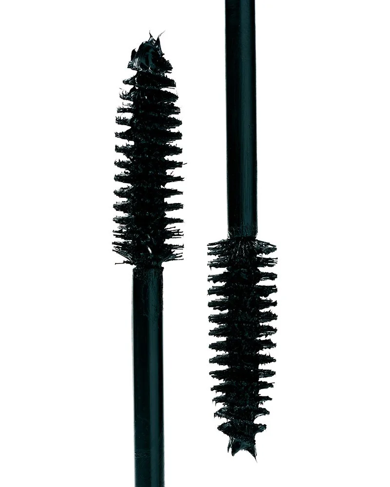 Two black mascara wands with bristles, one on the left and one on the right, against a white background.