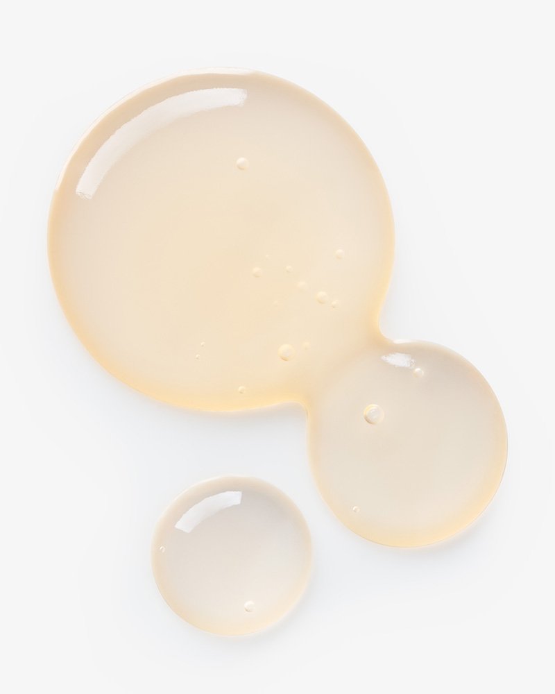 Three droplets of a collagen face serum on a white background.