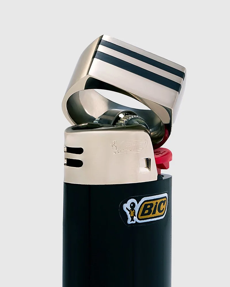 Striped sculptural ring styled on black Bic lighter, still life product photography by Sara Anderson, San Francisco