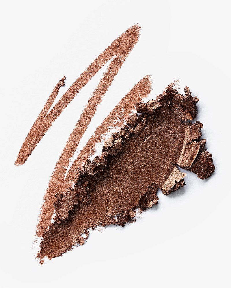 Close-up of brown makeup eyeshadow with swatches and broken powder