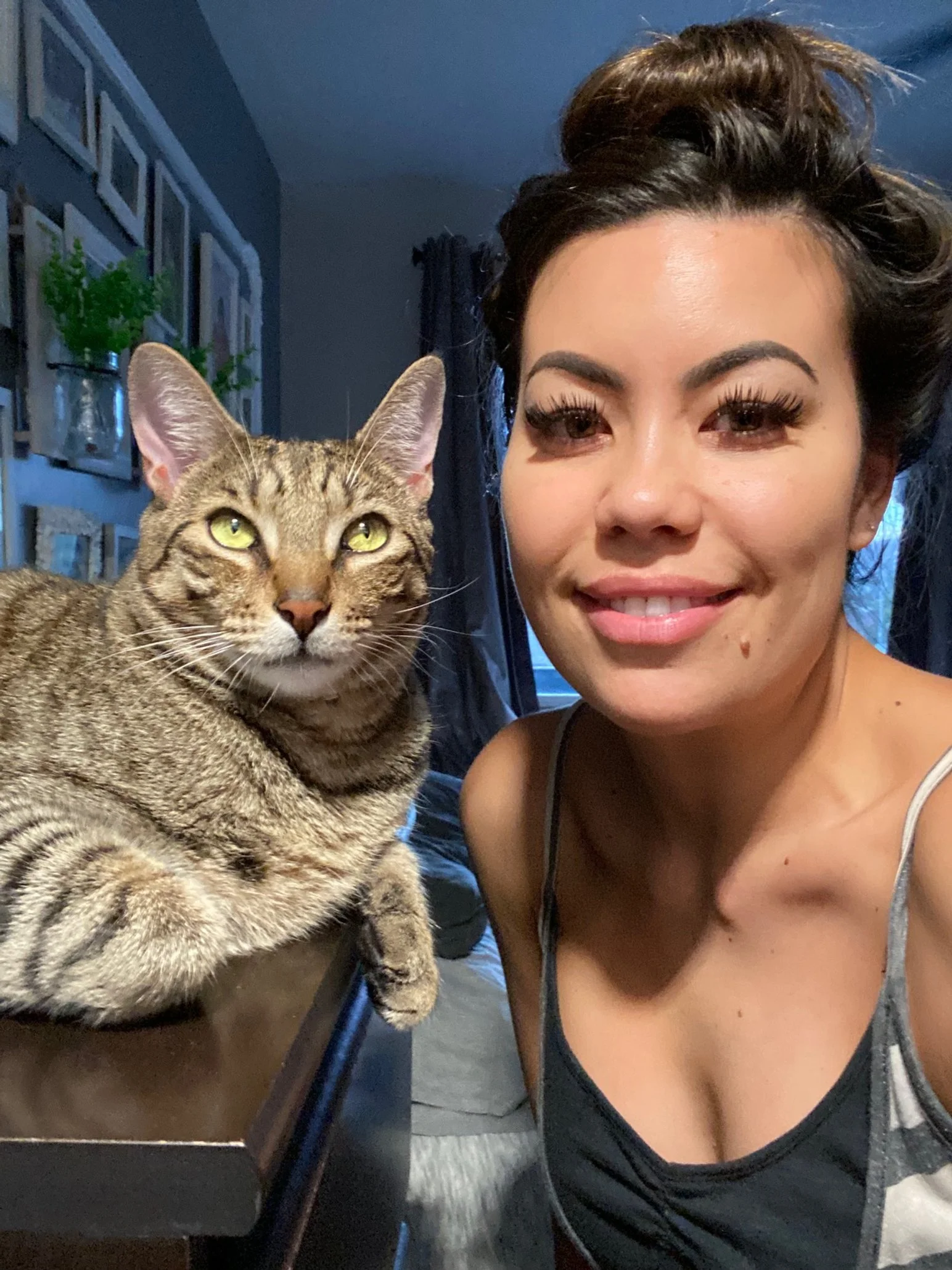 A woman smiling next to her pet cat