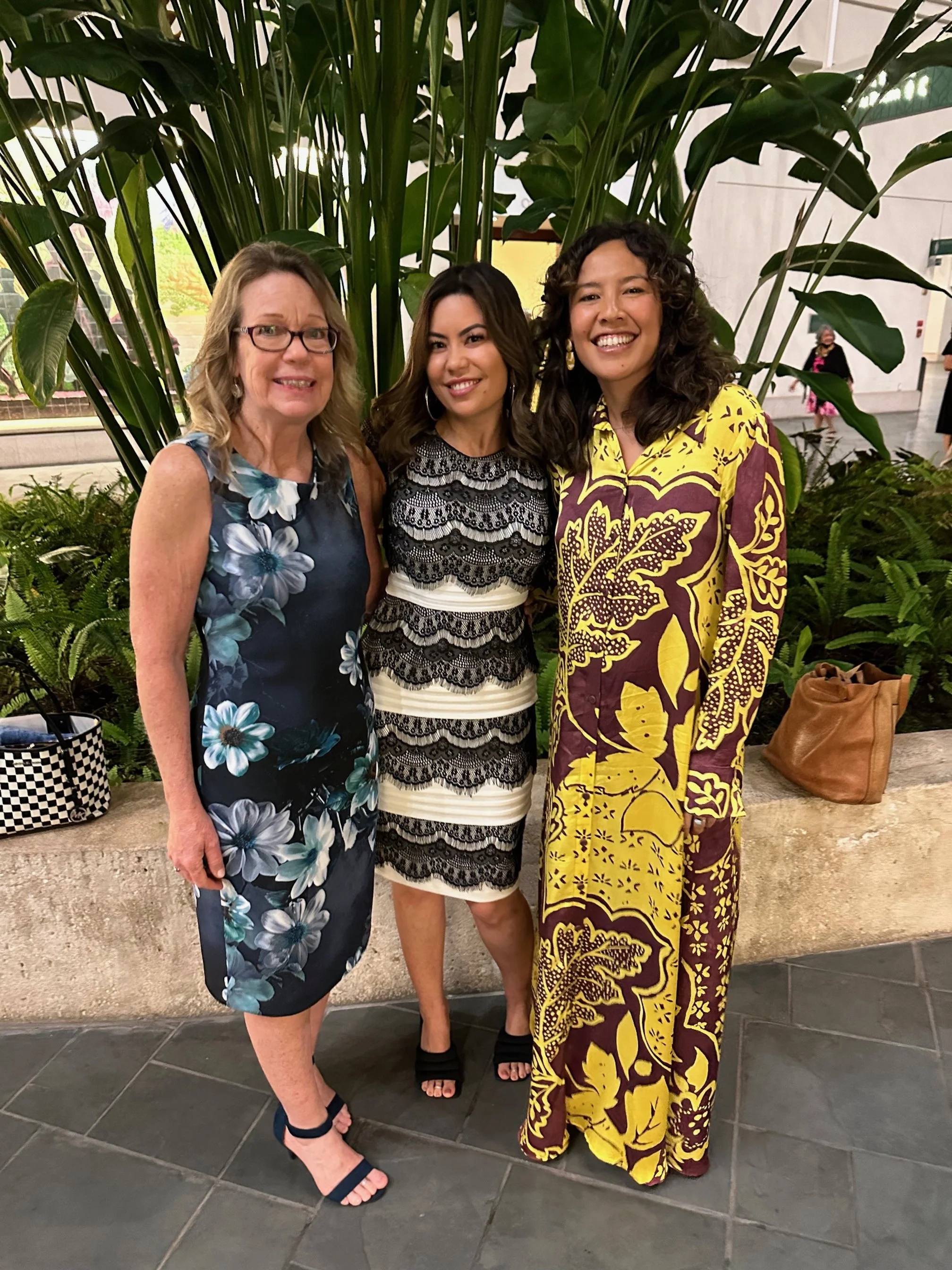 Three women smiling and embracing each other