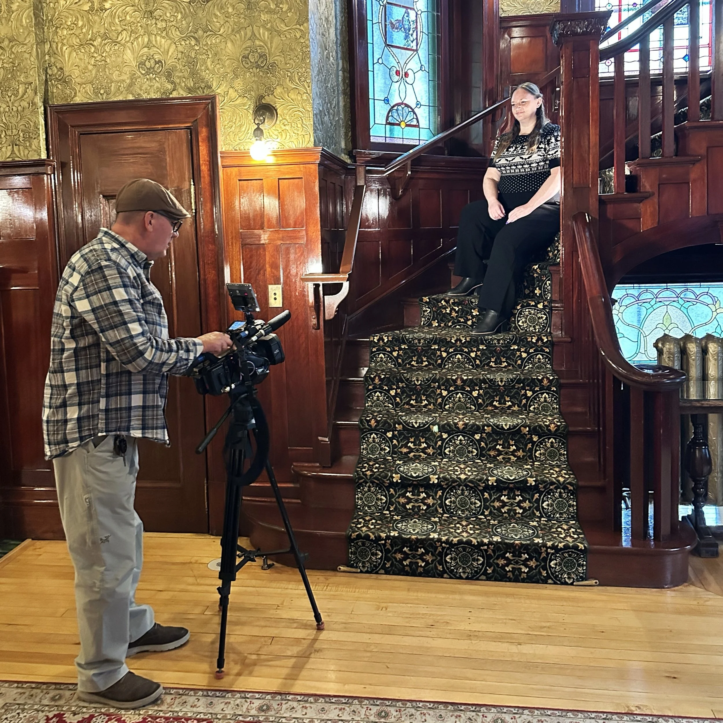 Staff member being on camera on the stairs